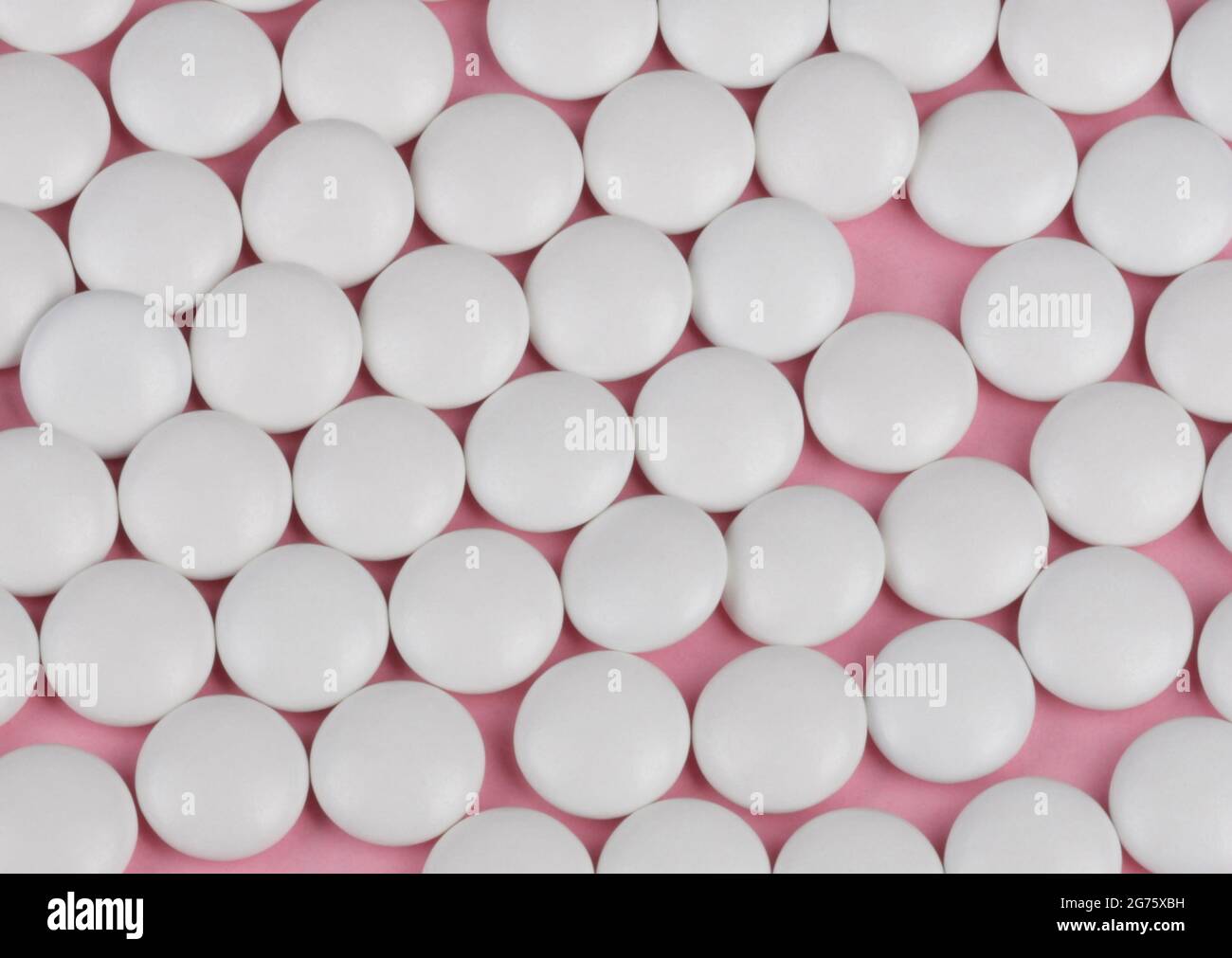 Pillola bianco su sfondo rosa Foto Stock