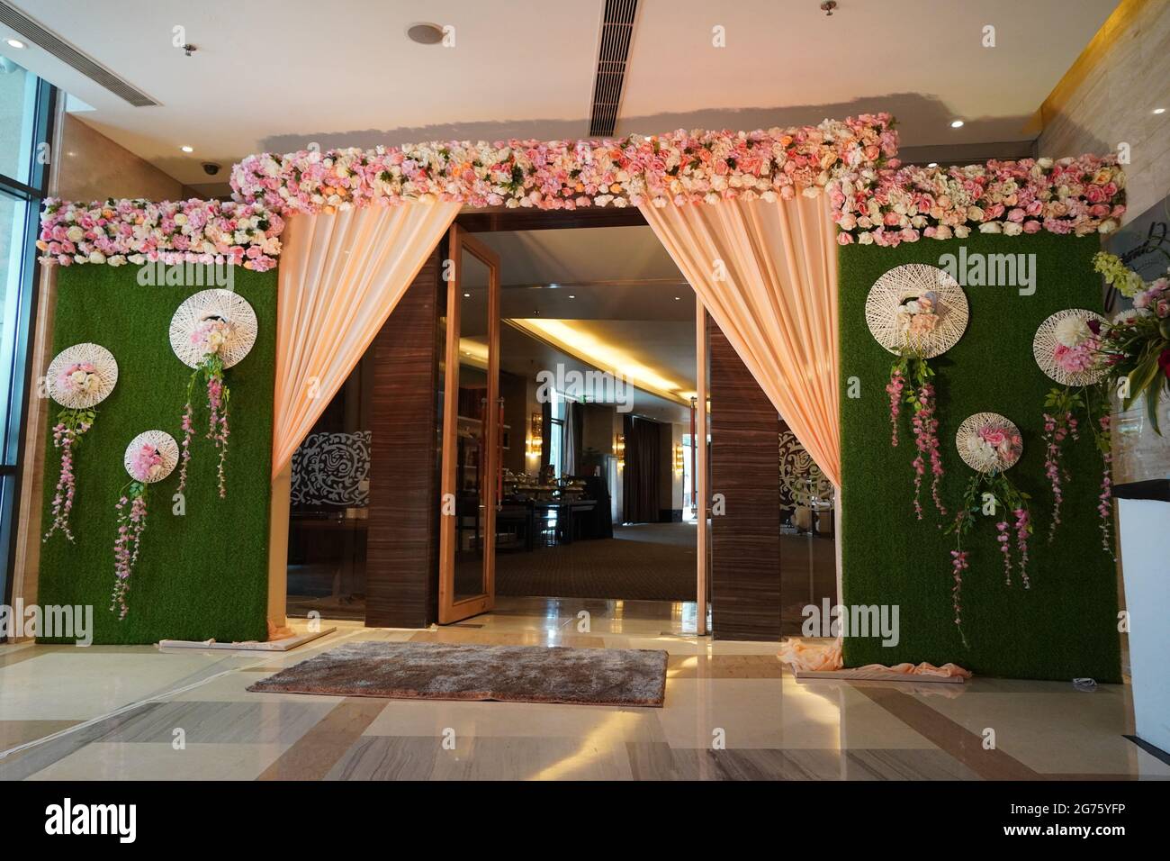 Elementi decorativi floreali per matrimoni. Luci, cancello d'ingresso, doccia, fiori, palco di coppia. Closeup splendido arco di nozze fiori all'ingresso del Foto Stock