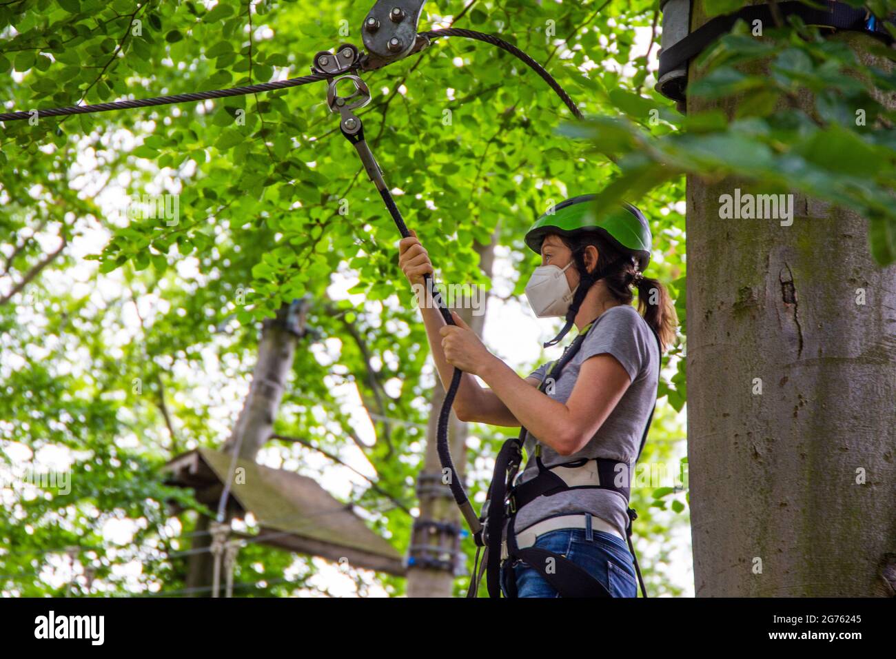 Eccessiva cautela, regolamentazione o abitudine? Donna con maschera FFP2 su un corso di arrampicata Foto Stock