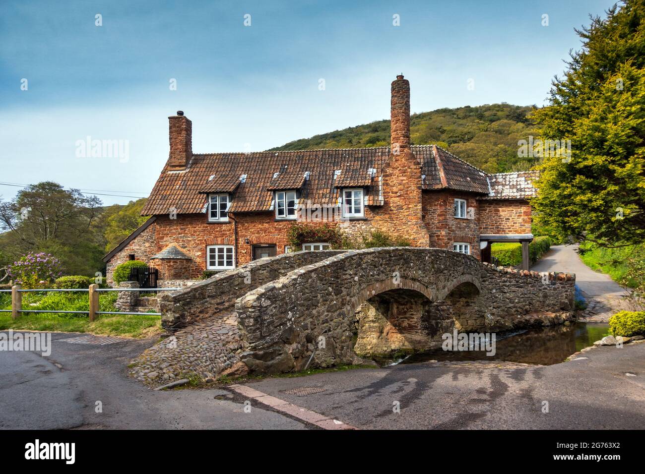 Il ponte medievale a cavallo e cottage nel pittoresco villaggio di Allerford nel Somerset. Foto Stock