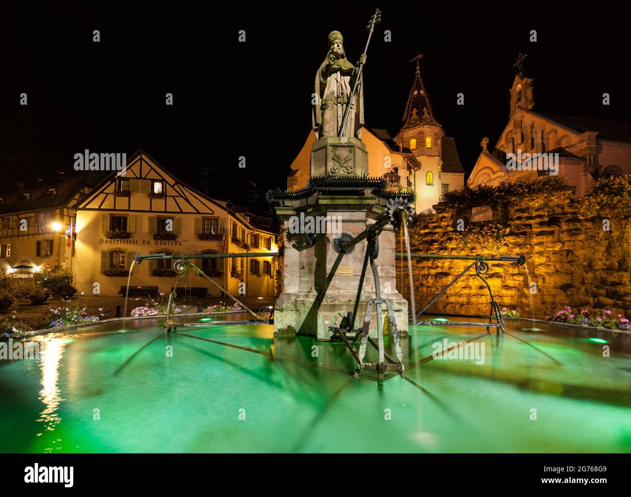 Eguisheim di notte: Statua di Papa Leone IX. (1002-1054) nella piazza del castello nella sua città natale, il villaggio dei viticoltori di Eguisheim nella regione Alsazia. Foto Stock
