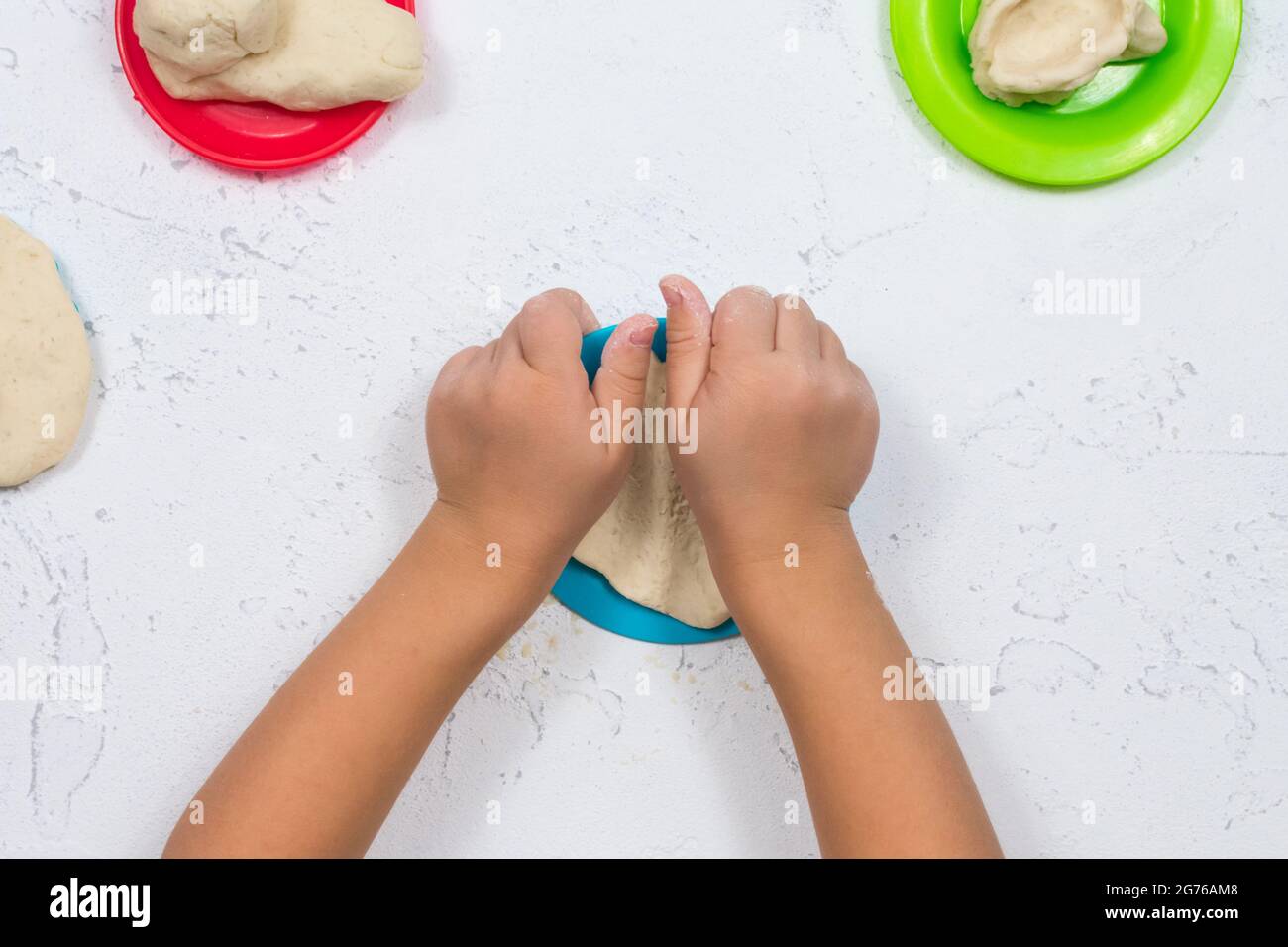 Le mani dei bambini sono scolpite dall'impasto di sale. Sviluppo di belle capacità motorie delle mani. Sviluppo della creatività dei bambini. Multicolore Foto Stock