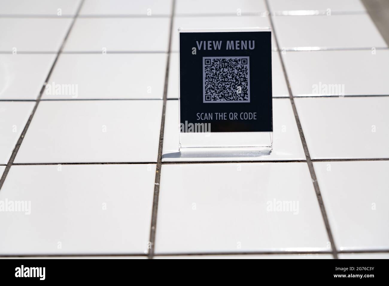 Visualizzare il menu e eseguire la scansione del simbolo del codice QR sul tavolo del bar Foto Stock