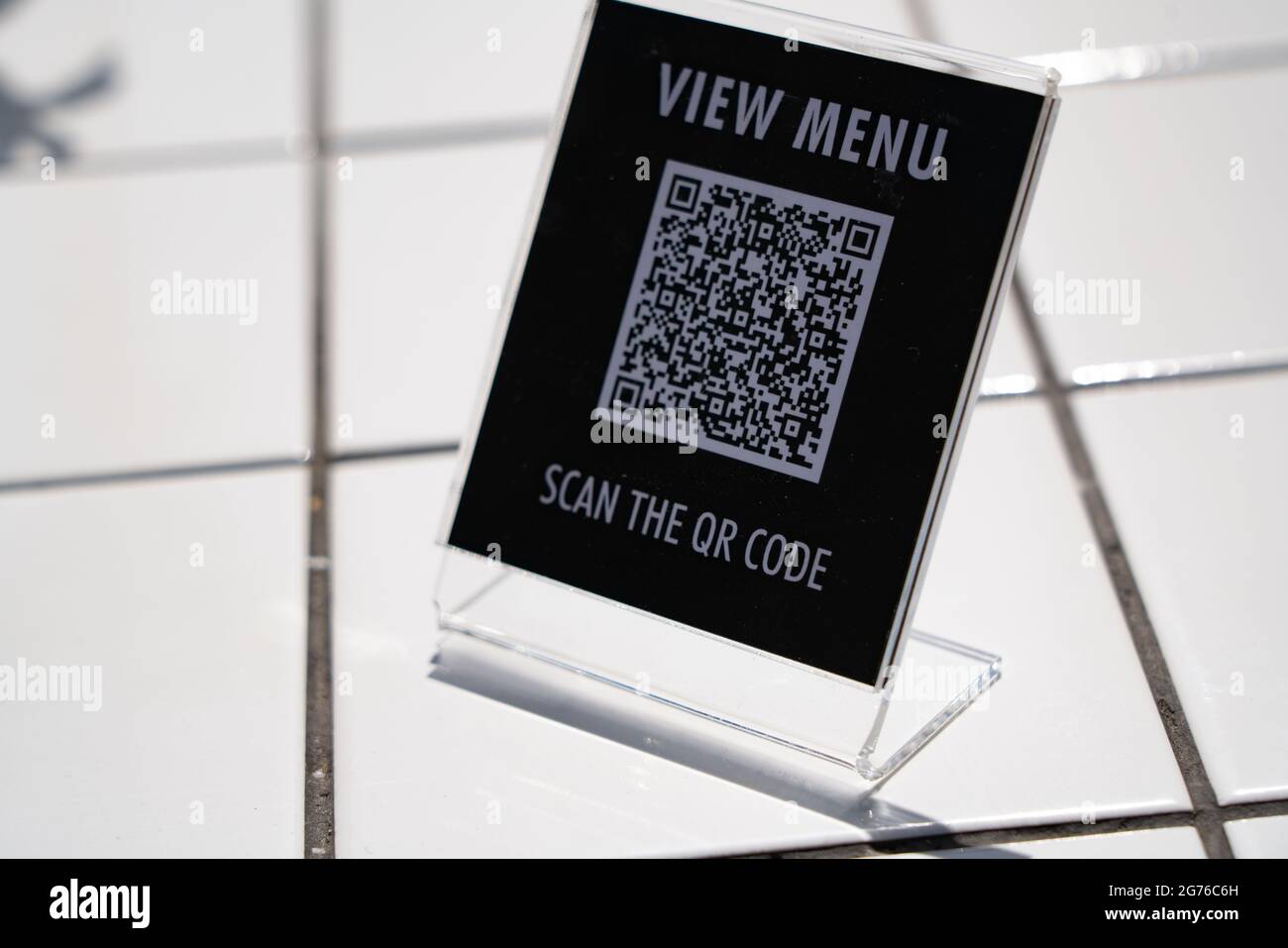 Visualizzare il menu e eseguire la scansione del simbolo del codice QR sul tavolo del bar Foto Stock