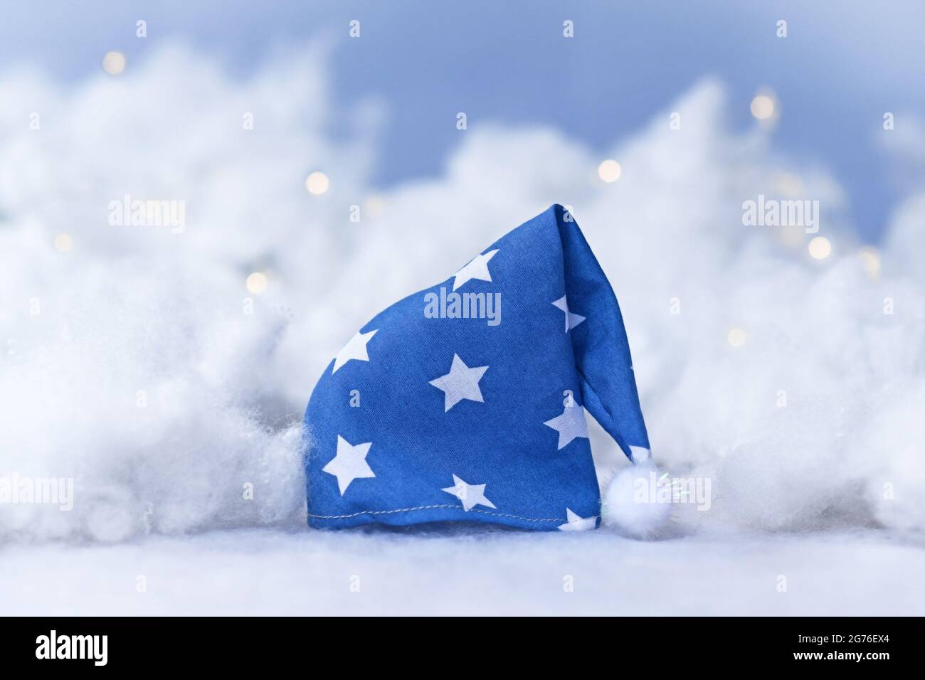 Cappellino blu con stelle circondate da nuvole e stelle Foto Stock