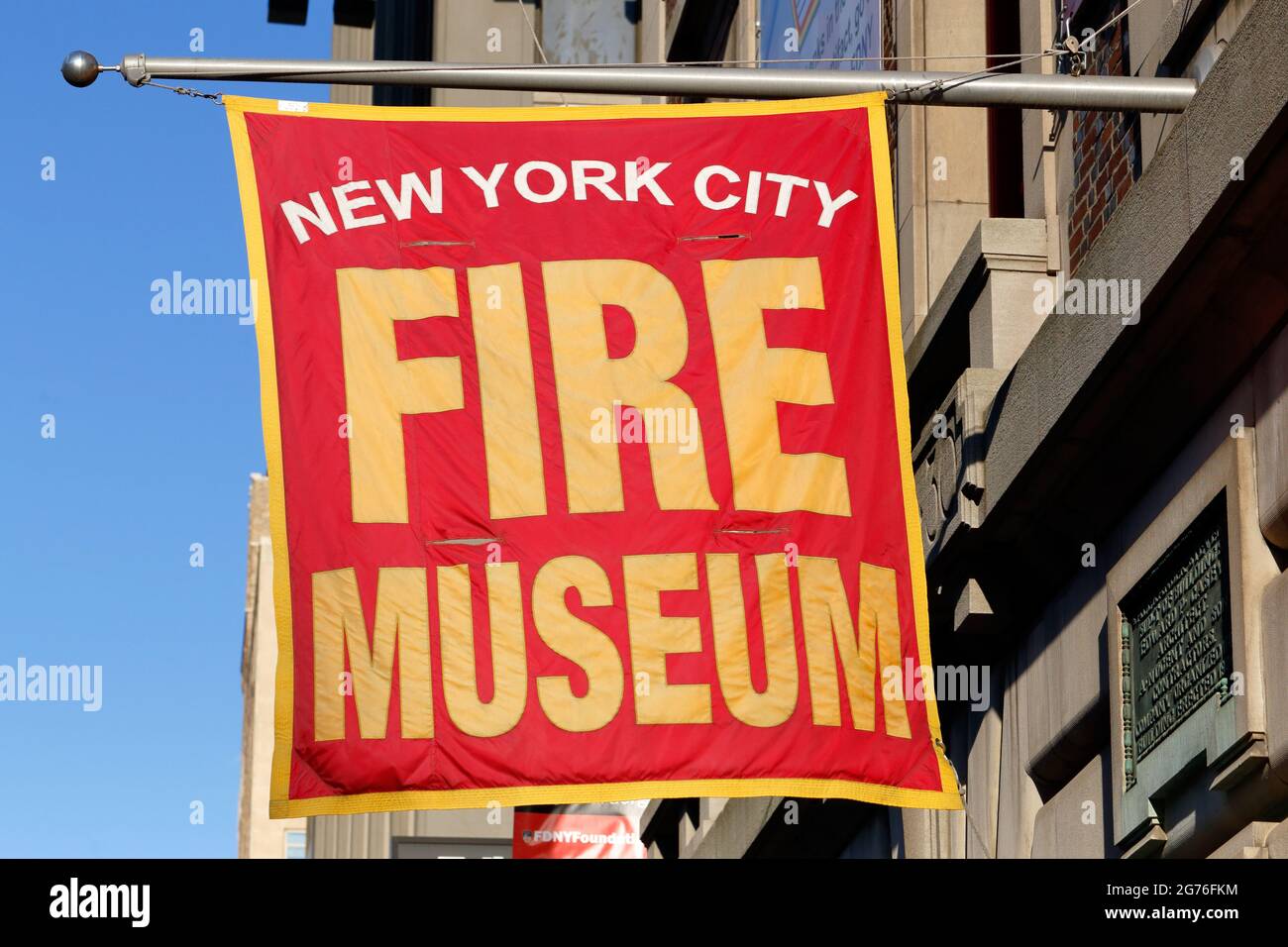 New York City Fire Museum, 278 Spring St, New York, New York. Cartello con la bandiera di fronte a un museo dedicato alla storia del fuoco nel quartiere Tribeca di Manhattan. Foto Stock
