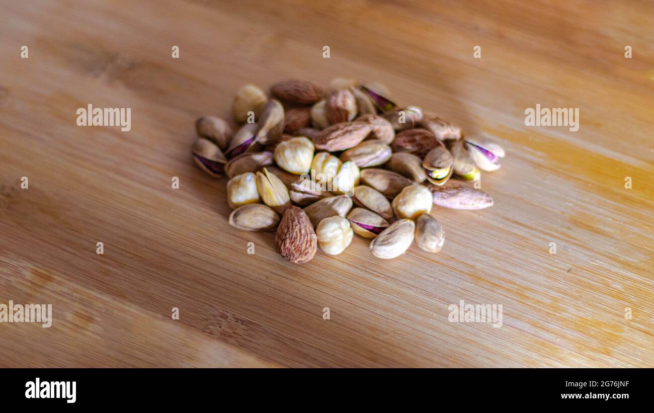 Frutta secca su fondo di legno, frutta secca e frutta, fuoco selettivo Foto Stock