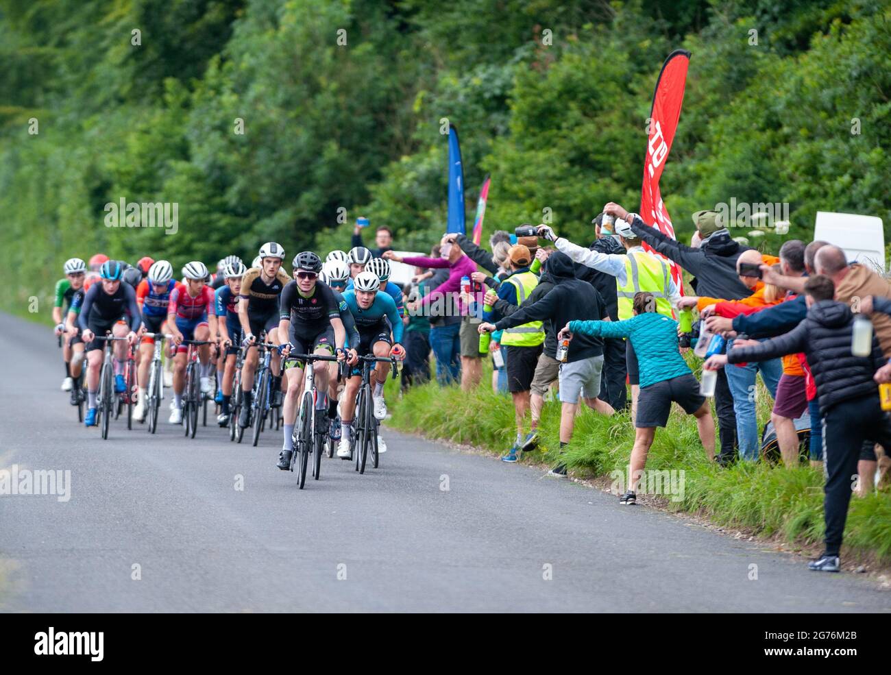 Pewsey, Inghilterra. 11 luglio 2021. Il peloton passa attraverso la zona di alimentazione al British Cycling Junior National Road Race Championships. Credit: David Partridge/Alamy Live News Foto Stock