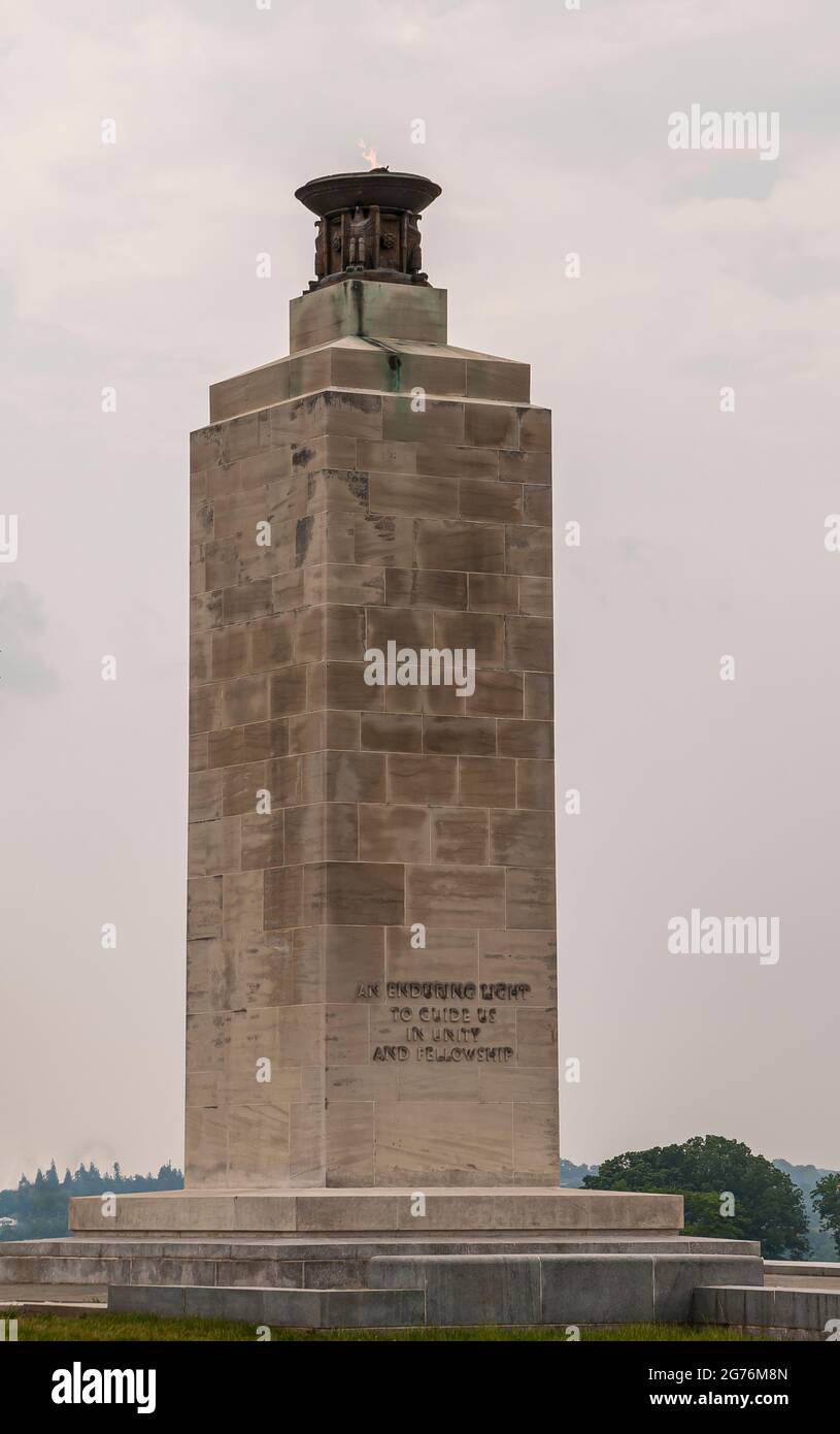 Gettysburg, PA, USA - 14 giugno 2008: Monumenti sul campo di battaglia. La colonna di pietra marrone è un monumento per la Pace leggera che dura nel tempo, con la fiamma eterna in cima contro il limo Foto Stock