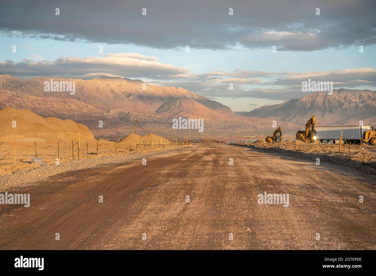 Ampia strada non asfaltata con cantiere sul lato Foto Stock