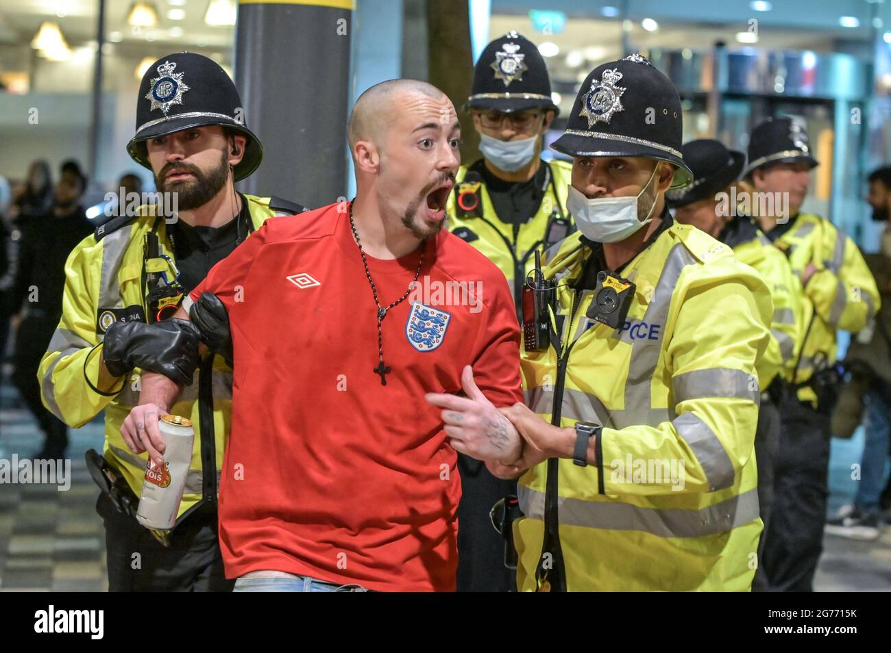 Broad Street, Birmingham 11 luglio 2021 i tifosi si sono scontrati l'uno con l'altro dopo che l'Inghilterra si è schiantata fuori dalla finale Euro 2020 con l'Italia che ha vinto a pene, rendendolo 56 anni di ferimento. I fan si sono rovesciati fuori dei pub e dei bar su Broad Street nel centro di Birmingham, mentre la polizia ha formato linee. Molti fan sembravano infeludati, una donna sembrava perduta mentre camminava attraverso le fontane. Una granata di fumo è stata lanciata anche mentre la polizia ha cercato di calmare i sostenitori, anche se un kit inglese con un ventilatore ha fatto sventolare una bottiglia di vodka in aria prima che la polizia minacciasse di usare il gas se non lo ha fatto cadere. L'uomo è stato poi arrestato. Foto Stock