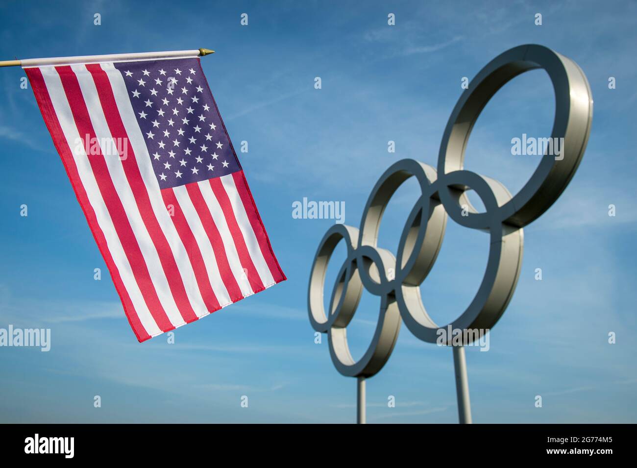 RIO DE JANEIRO - 4 MAGGIO 2016: Una stella e striscia bandiera USA di fronte agli anelli olimpici contro il blu luminoso Foto Stock