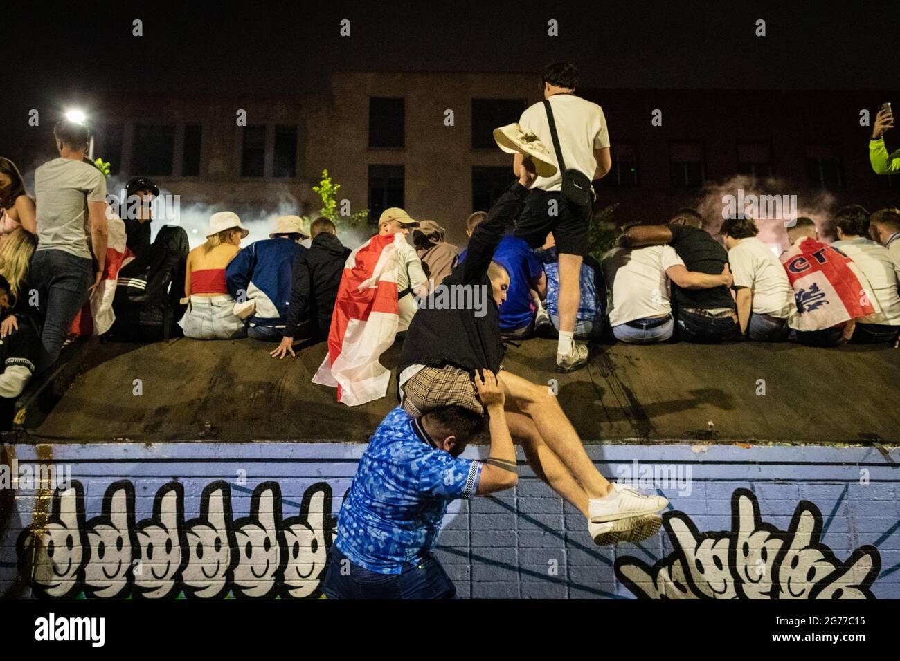 Manchester, Regno Unito. 11 Luglio 2021. Un uomo aiuta un amico fan dell'Inghilterra a festeggiare senza perdere l'Italia nella finale di Euro2020.ÊAndy Barton/Alamy Live News Credit: Andy Barton/Alamy Live News Foto Stock