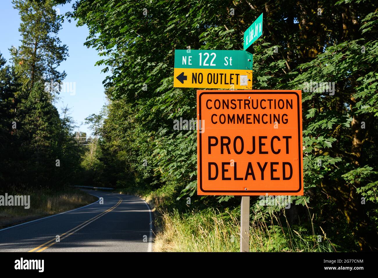 Garofano, WA, USA - 11 luglio 2021; un cartello arancione e nero sulla strada informa che il progetto di costruzione della strada è in ritardo Foto Stock