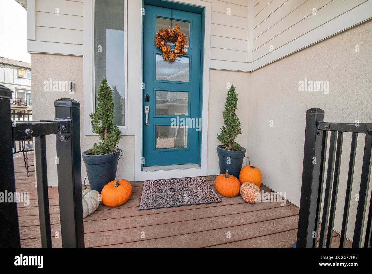 Esterno di una casa con porta anteriore blu e lato parete in vinile. Foto Stock