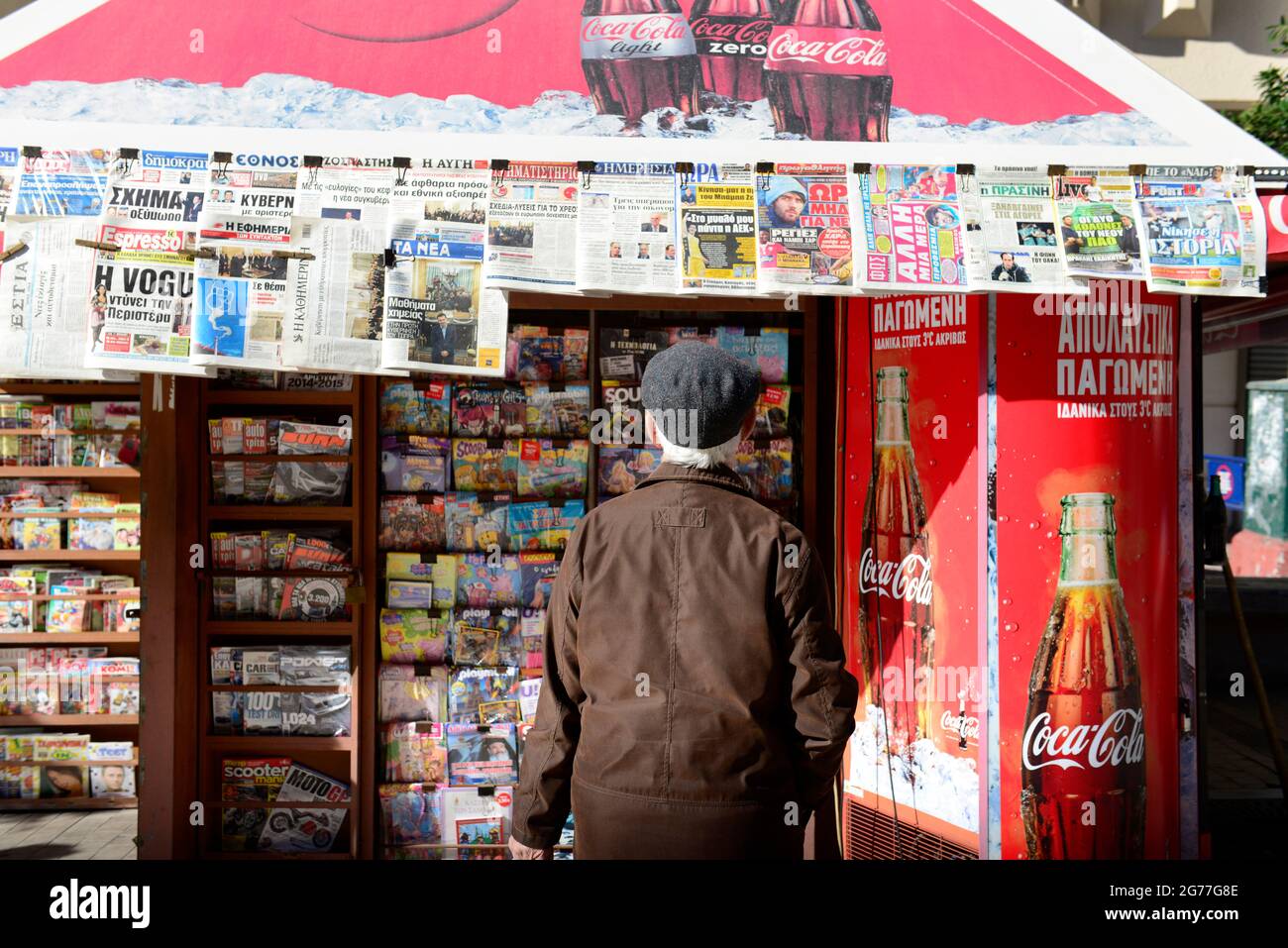 Un greco che legge le notizie del mattino in uno stand di giornali durante i disordini politici in Grecia alla fine di gennaio 2015. Foto Stock