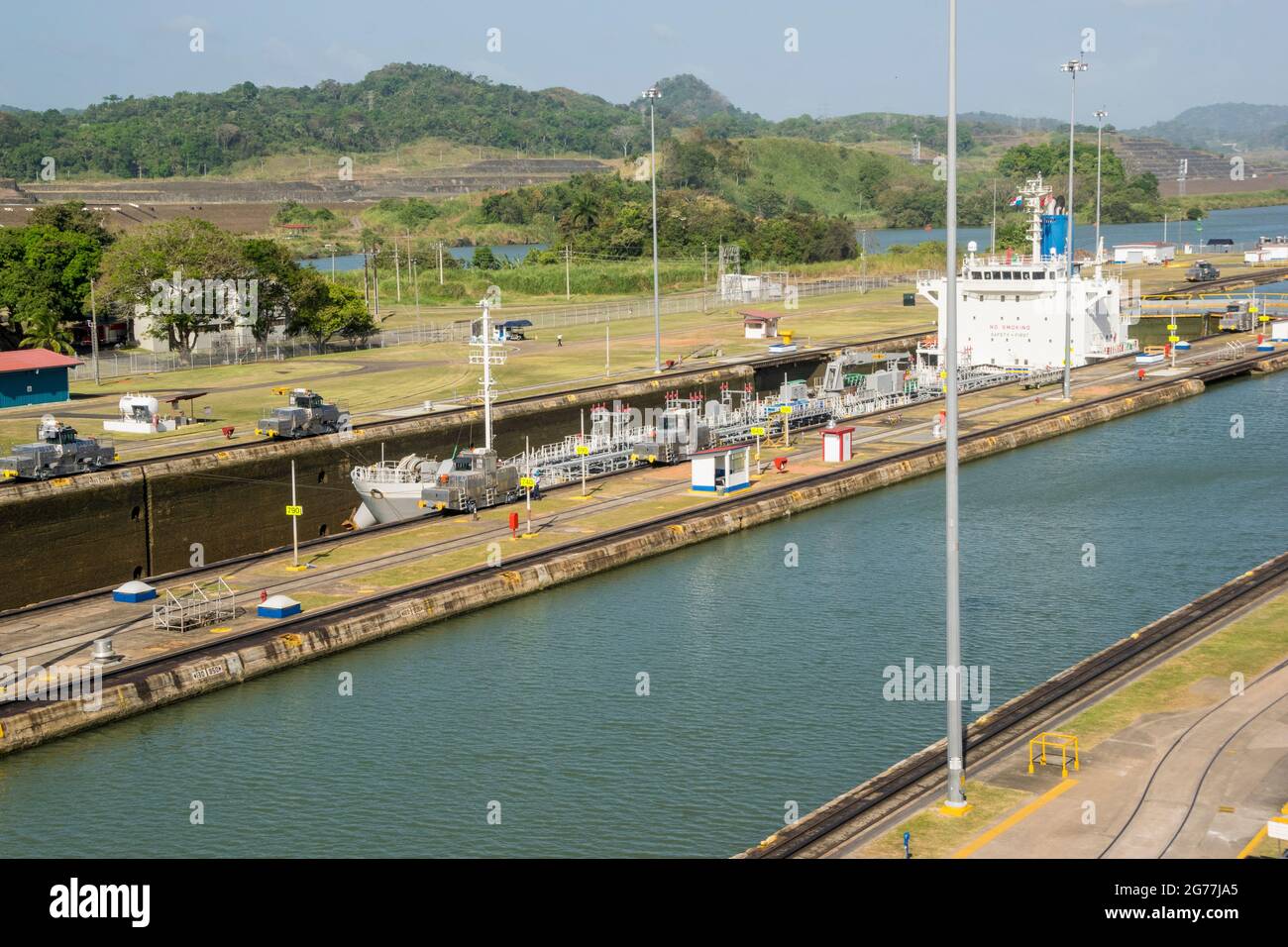 Un grande carico passò appena attraverso il canale di Panama in una giornata di sole. Si possono vedere gli uffici principali e una delle serrature. Foto Stock