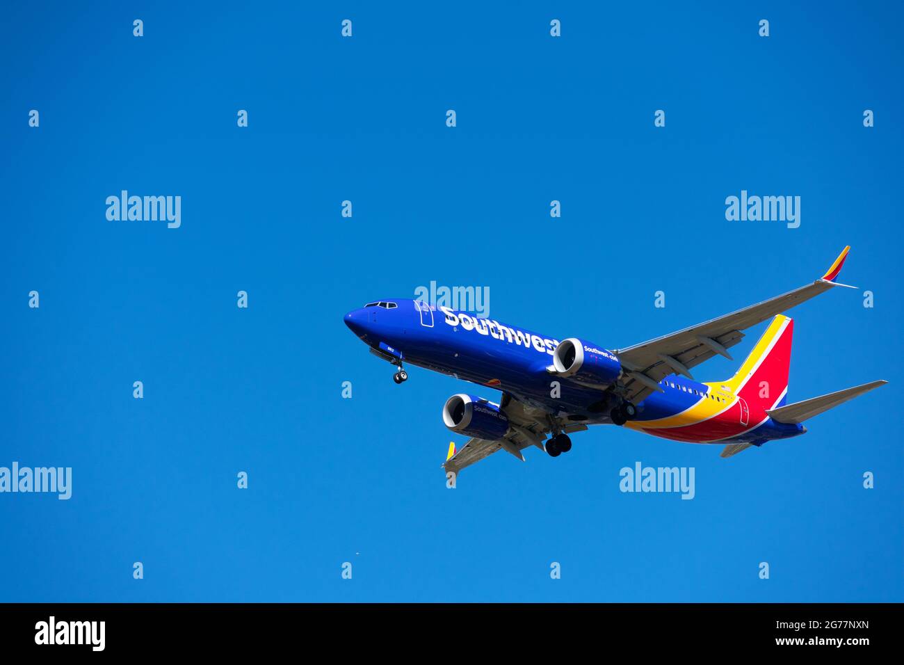 L'aereo di linea Boeing 737 MAX 8 gestito da Southwest Airlines si prepara all'atterraggio in aeroporto con l'attrezzatura di atterraggio attivata. Cielo blu - San Jose, Cali Foto Stock