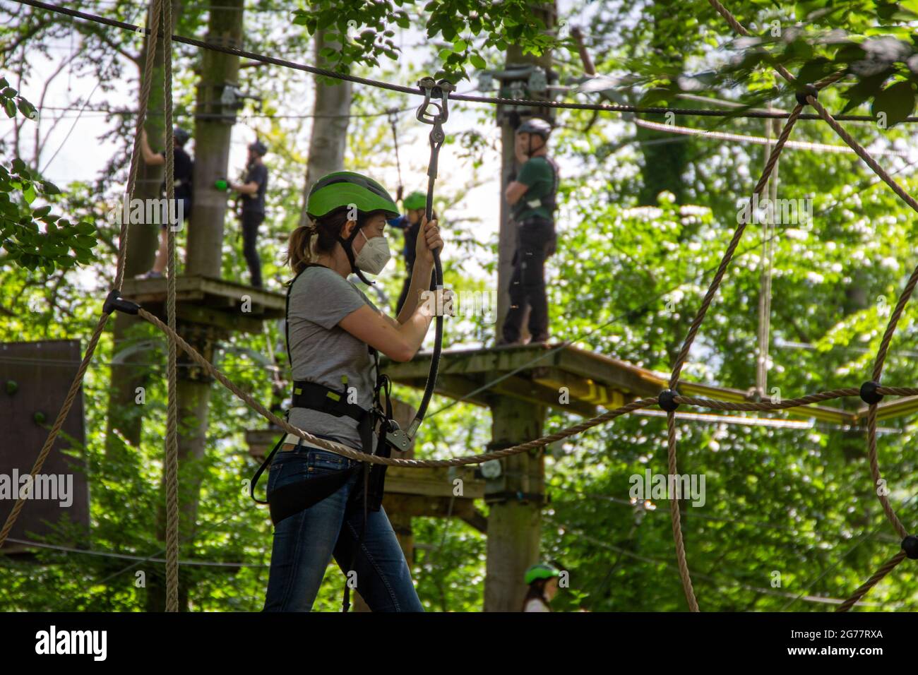 Eccessiva cautela, regolamentazione o abitudine? Donna con maschera FFP2 su un corso di arrampicata Foto Stock