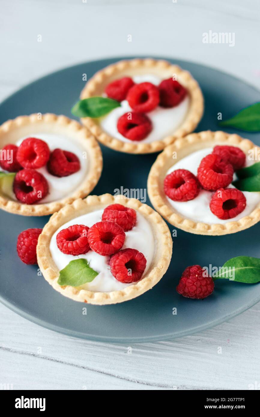 Tartine con panna e lampone su tavola di legno bianco Foto Stock