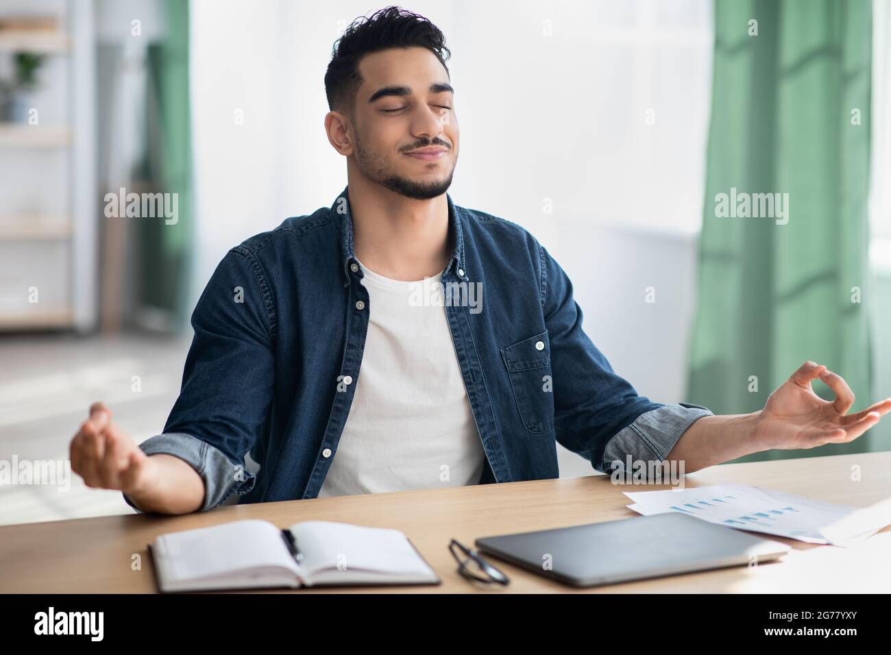 Il giovane dipendente arabo si calma dopo una giornata di lavoro stressante Foto Stock