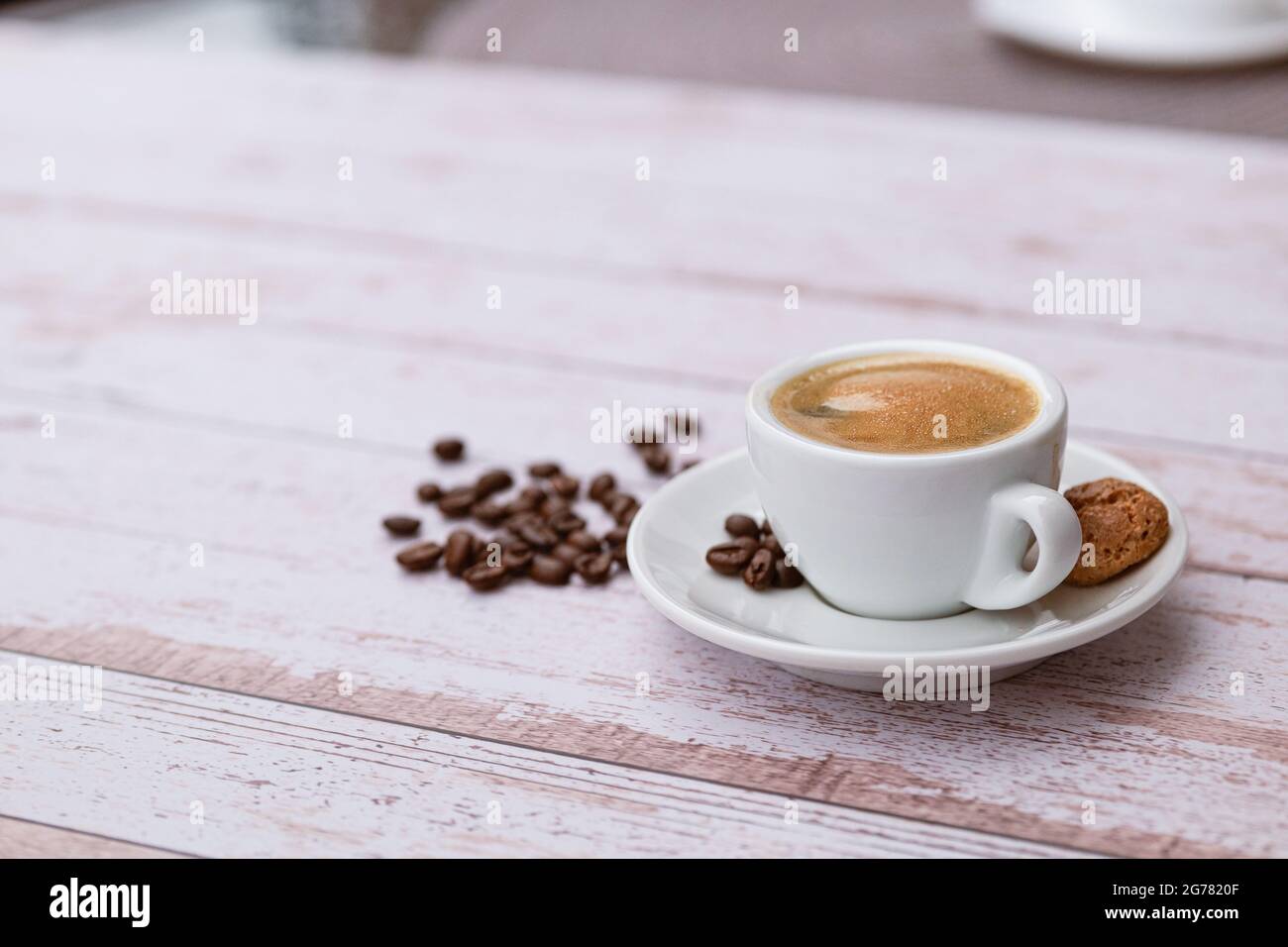 Tazza di caffè con fagioli su un tavolo di legno chiaro. Foto Stock