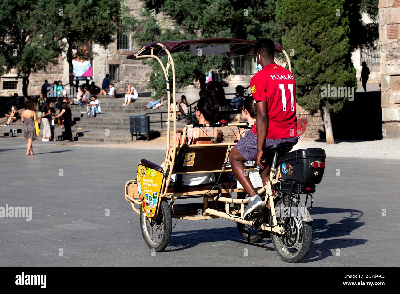 Bicicletta risciò che porta i turisti oltre la cattedrale, Barcellona, Spagna. Foto Stock