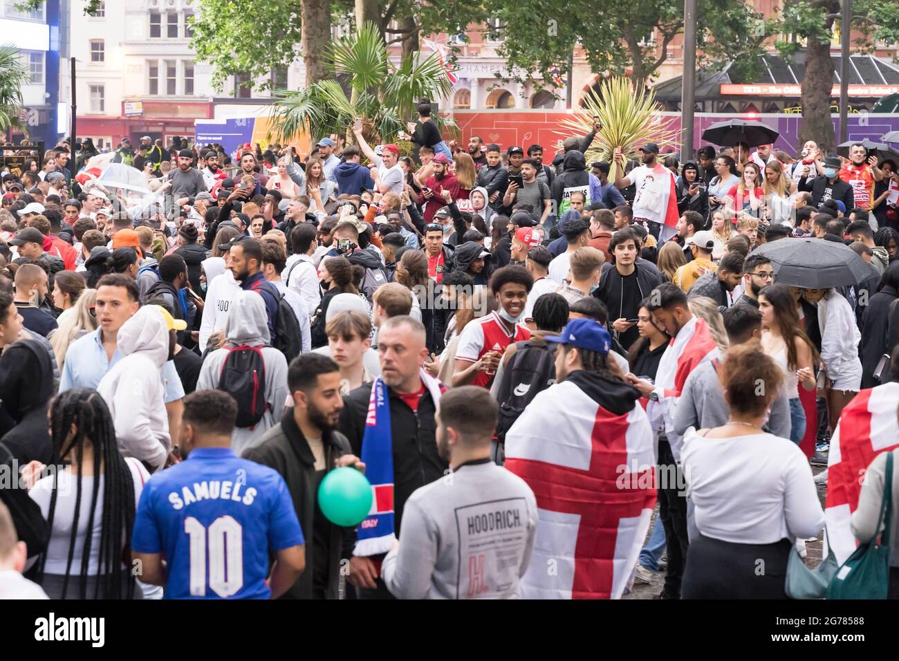 Gli appassionati di calcio inglesi che cantano, cantano e lasciano i fumetti si riuniscono nel centro di Londra a Leicester Square a euro 2020 final , Inghilterra Foto Stock