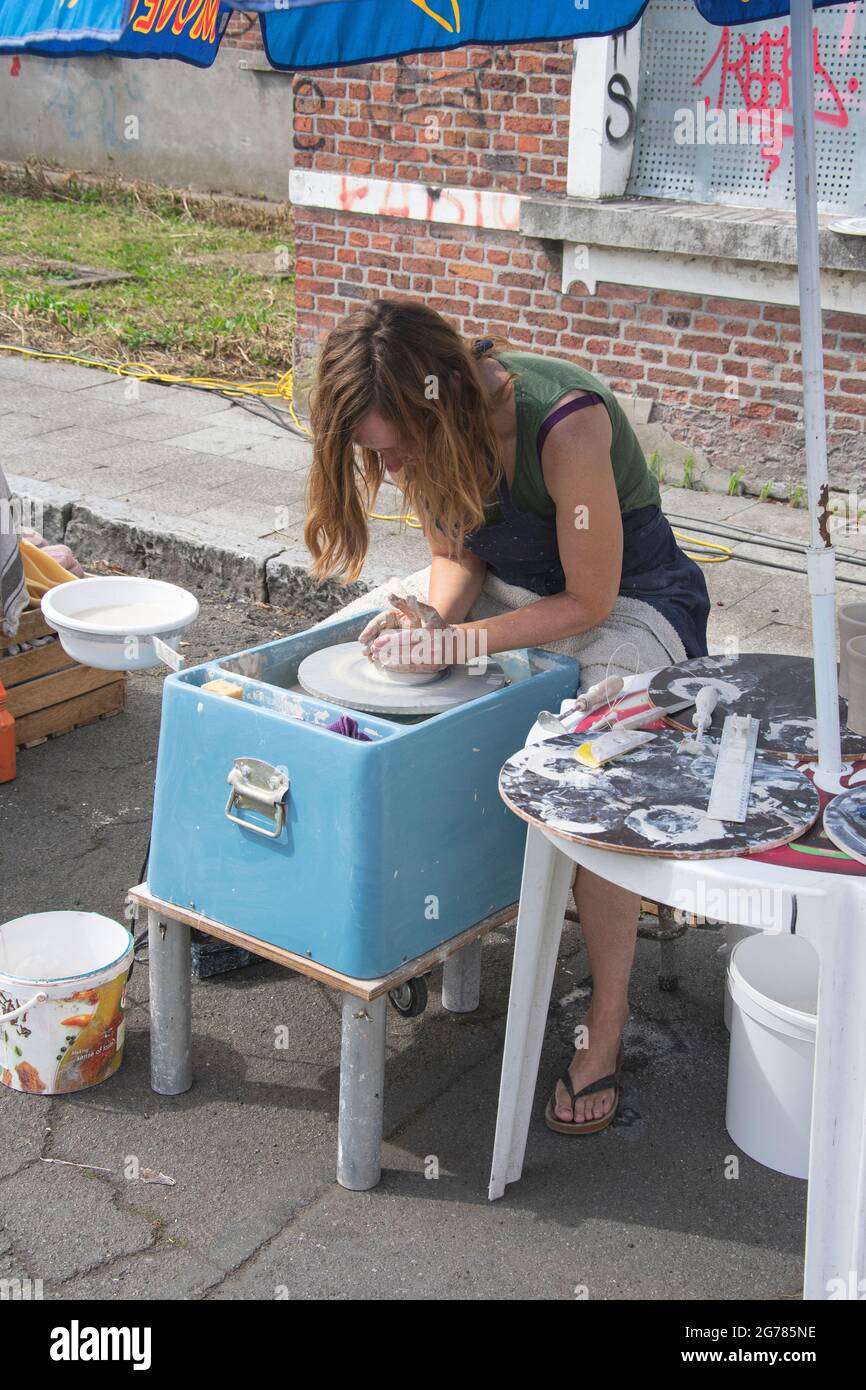 Doel, Belgio, 11 agosto 2019, lavoratori artigiani, donna sta facendo ceramica o girando pentole fuori di creta e all'aria aperta Foto Stock