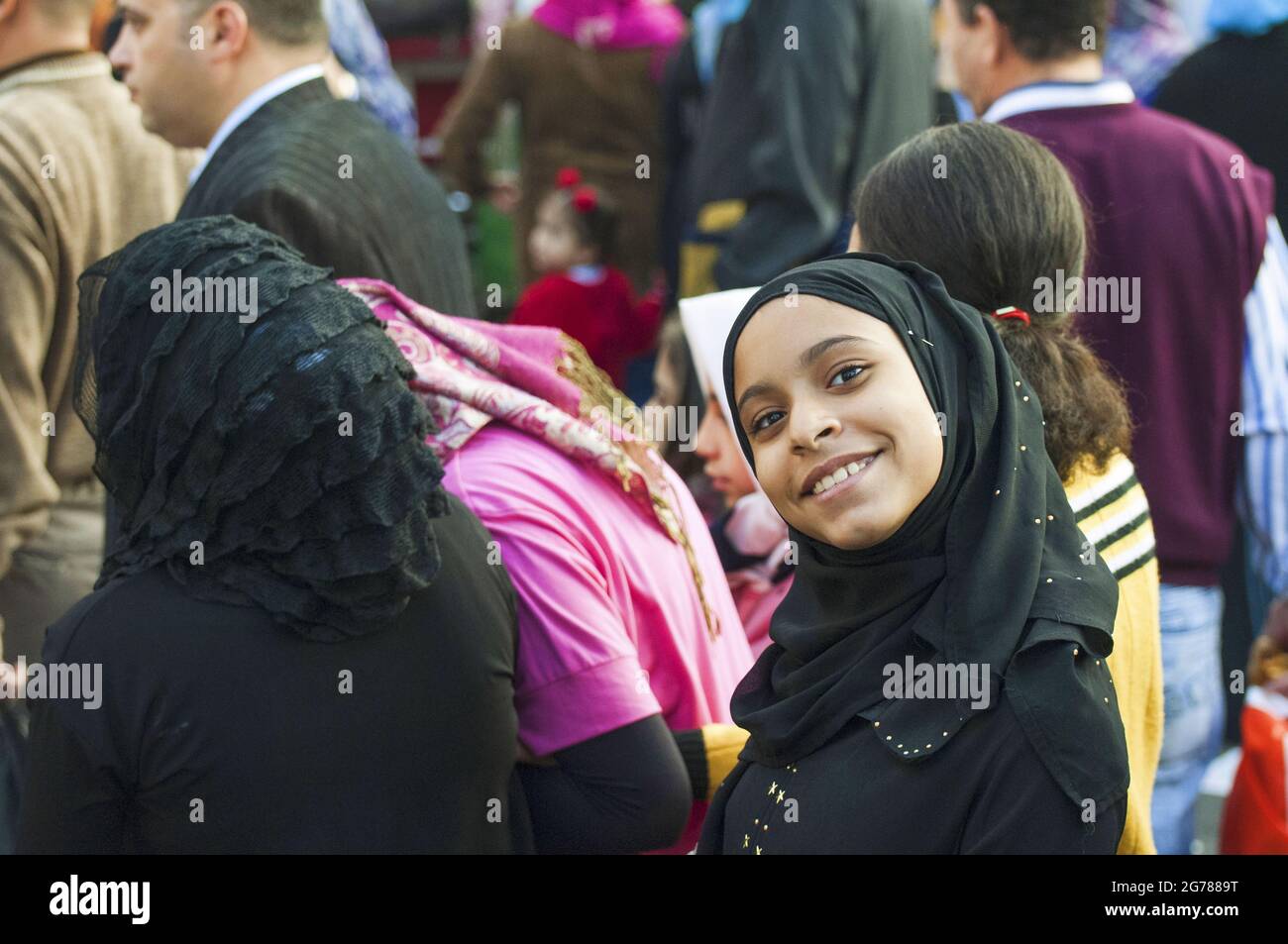 Una giovane donna tra una folla di adoratori al festival Eid el Adha (festa del sacrificio) a Mohandiseen, il Cairo, Egitto Foto Stock