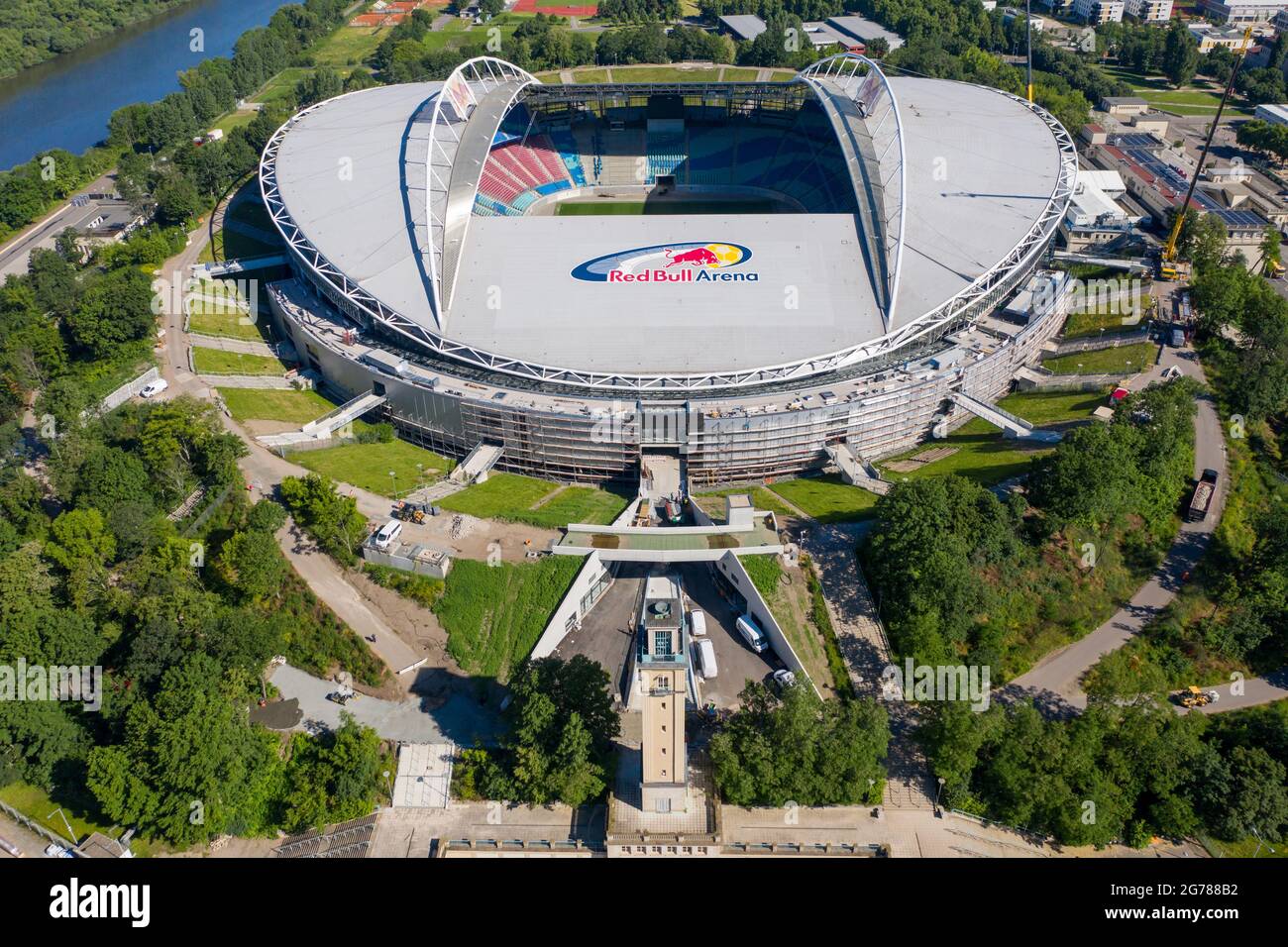 14 giugno 2021, Sassonia, Lipsia: Due gru si trovano alla Red Bull Arena. La casa di RB Leipzig è in fase di ricostruzione. La capacità dello spettatore aumenta da 42,558 a 47,069 in piedi e seduti. L'esterno dello stadio è chiuso con una facciata insonorizzata. L'argine dell'ex Zentralstadion, che comprende l'arena, è stato aperto dietro lo storico campanile per fare spazio ad un nuovo ingresso. RB Leipzig sta investendo nella conversione 60 milioni di euro entro il 2022. (Vista aerea con drone) Foto: Jan Woitas/dpa-Zentralbild/ZB - NOTA IMPORTANTE: In conformità con le norme di t Foto Stock
