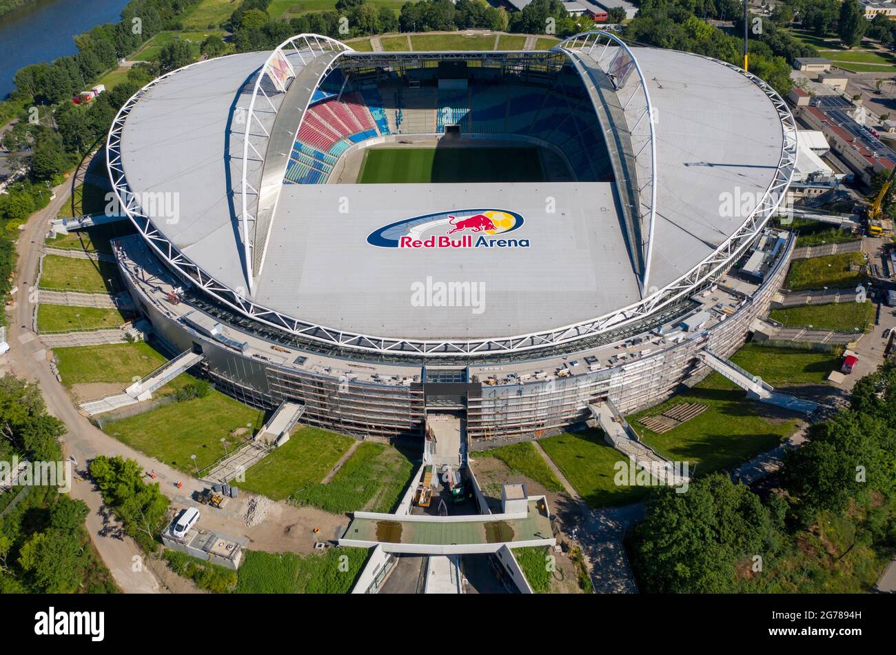 14 giugno 2021, Sassonia, Lipsia: Due gru si trovano alla Red Bull Arena. La casa di RB Leipzig è in fase di ricostruzione. La capacità dello spettatore aumenta da 42,558 a 47,069 in piedi e seduti. L'esterno dello stadio è chiuso con una facciata insonorizzata. L'argine dell'ex Zentralstadion, che comprende l'arena, è stato aperto dietro lo storico campanile per fare spazio ad un nuovo ingresso. RB Leipzig sta investendo nella conversione 60 milioni di euro entro il 2022. (Vista aerea con drone) Foto: Jan Woitas/dpa-Zentralbild/ZB - NOTA IMPORTANTE: In conformità con le norme di t Foto Stock