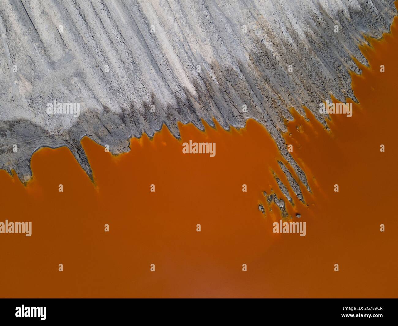 Acqua rosso arancio sulla miniera di titanio. Contesto industriale. Inquinamento idrico Foto Stock