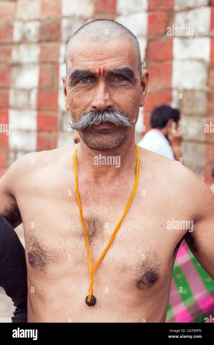 Primo piano ritratto di un adoratore indù con testa calva e baffi da manubrio in posa per fotocamera, Kanyakumari, Tamil Nadu, India Foto Stock