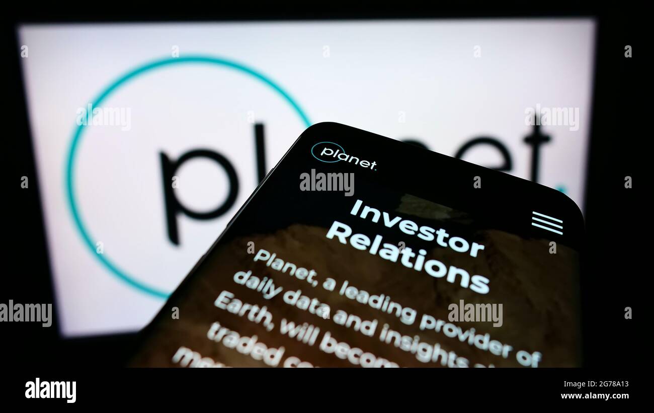 Smartphone con il sito Web della società di imaging della Terra americana Planet Labs Inc. Sullo schermo davanti al logo aziendale. Mettere a fuoco in alto a sinistra del display del telefono. Foto Stock