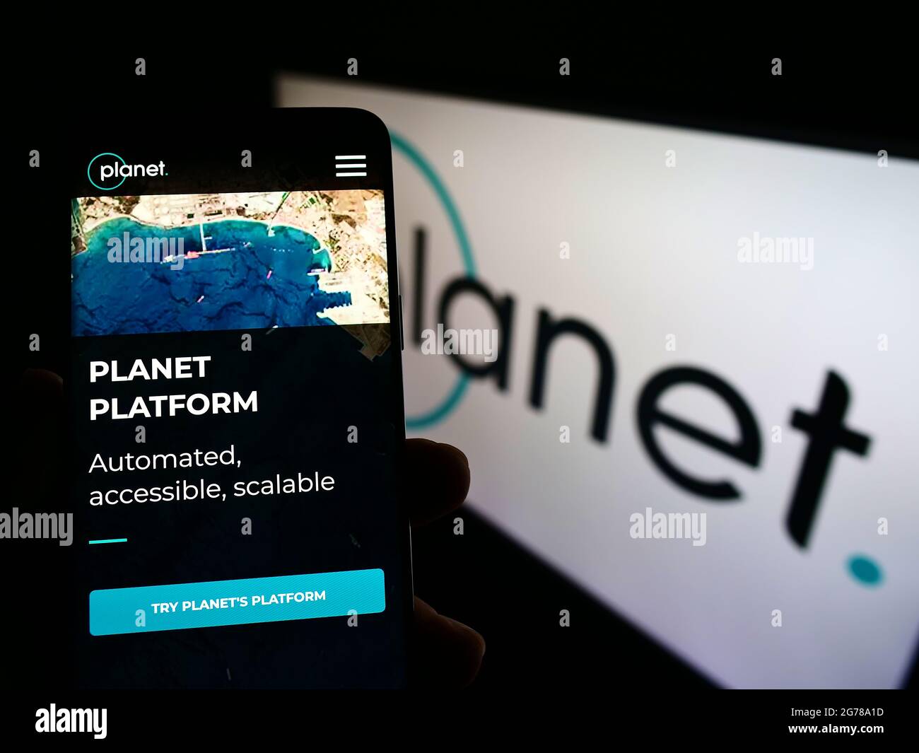 Persona che tiene il telefono mobile con la pagina web della società di imaging terrestre degli Stati Uniti Planet Labs Inc. Sullo schermo davanti al logo. Mettere a fuoco il centro del display del telefono. Foto Stock