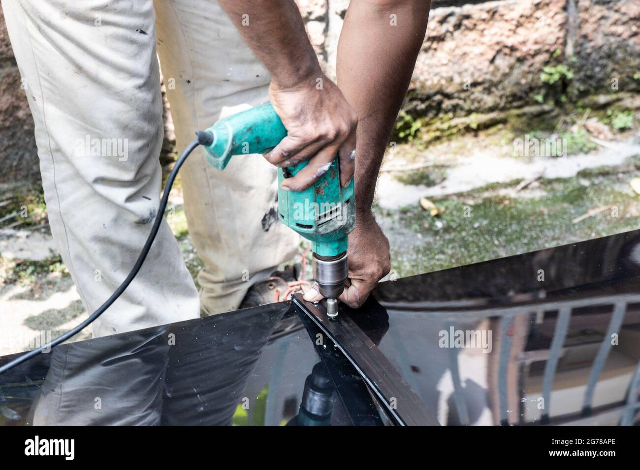 Operatore che perfora il telo in policarbonato del tetto con vite sul  telaio della struttura Foto stock - Alamy