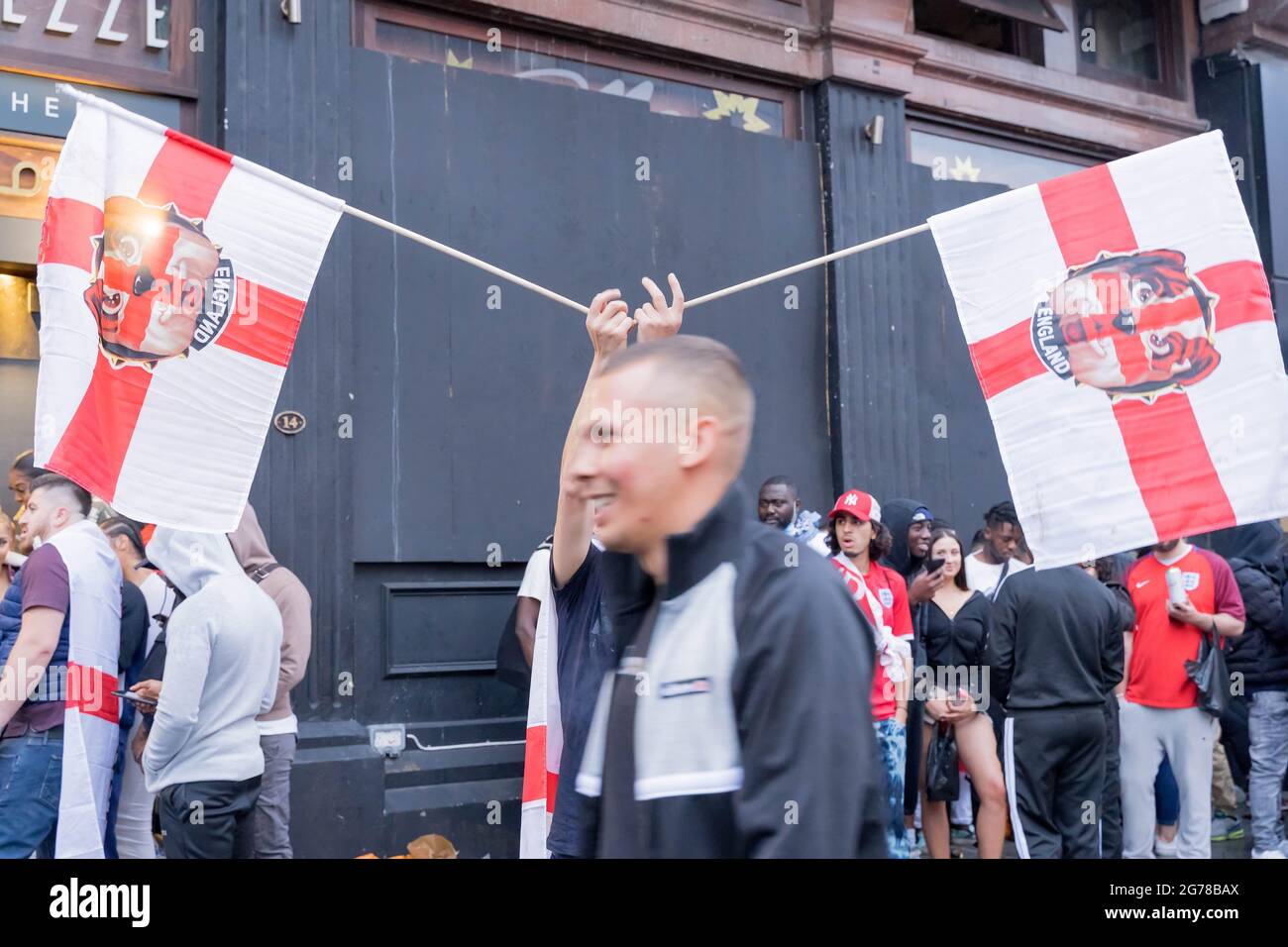 Gli appassionati di calcio inglesi che detengono bandiere si riuniscono nel centro di Londra vicino a Trafalgar Square a euro 2020 final , Inghilterra Foto Stock