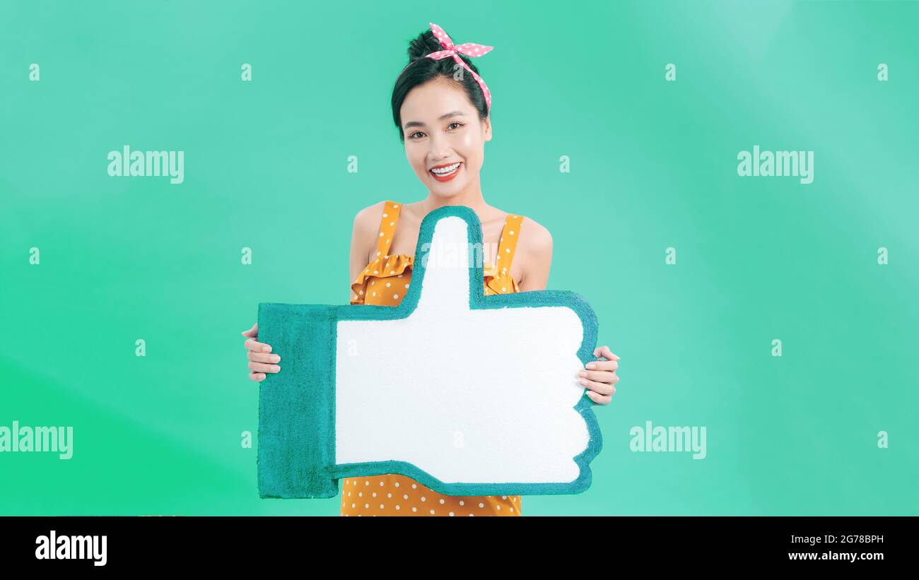 Pulsante mi piace. Donna felice che tiene i pollici su icona, segno di notifica seguace, raccomandazione e buon feedback nei social media. Foto Stock