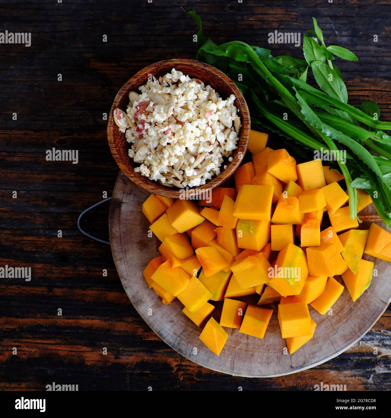 Vista dall'alto della materia prima per cucinare la zuppa di zucca con le arachidi e le spezie di coriandolo, piatto semplice per il pasto vegano vietnamita, ingredienti sul tagliere pronti Foto Stock