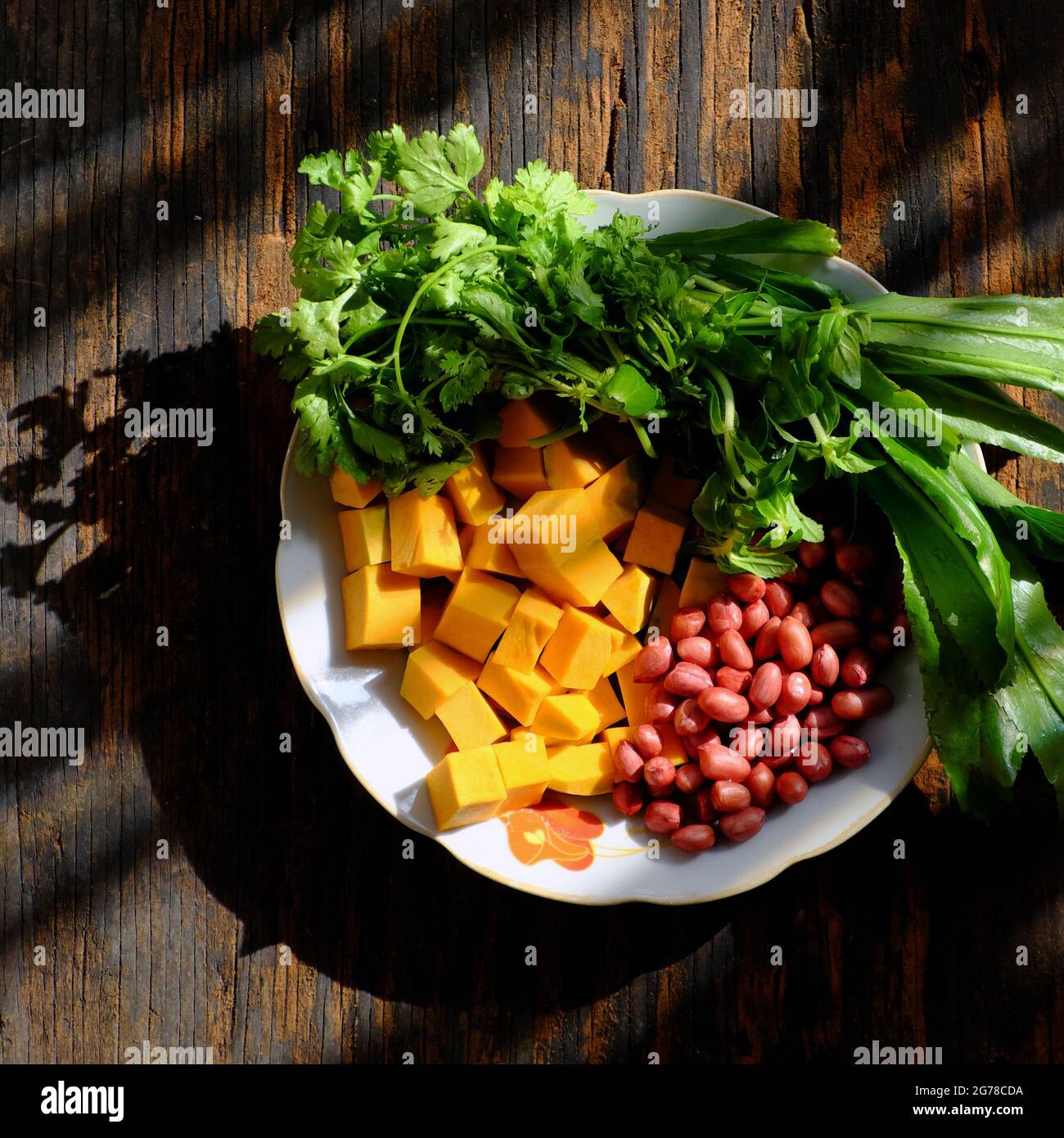 Vista dall'alto della materia prima per cucinare la zuppa di zucca con le arachidi e le spezie di coriandolo, piatto semplice per il pasto vegano vietnamita, ingredienti sul tagliere pronti Foto Stock