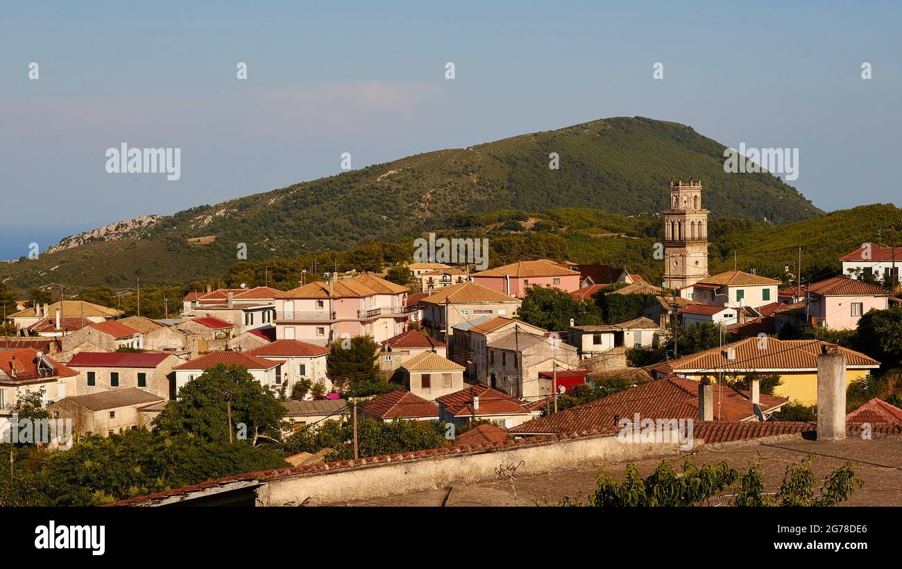 Isole IONIE, Zante, villaggio Kiliomenos, vista panoramica del luogo, torre della chiesa elemento centrale, colline sullo sfondo, cielo azzurro con copertura nuvola chiaro Foto Stock