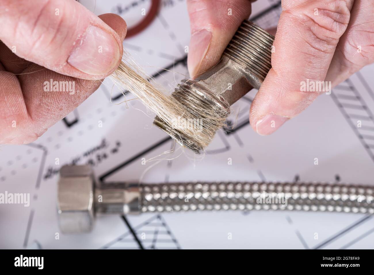Idraulico che mette le fibre della canapa su un filo, closeup Foto stock -  Alamy