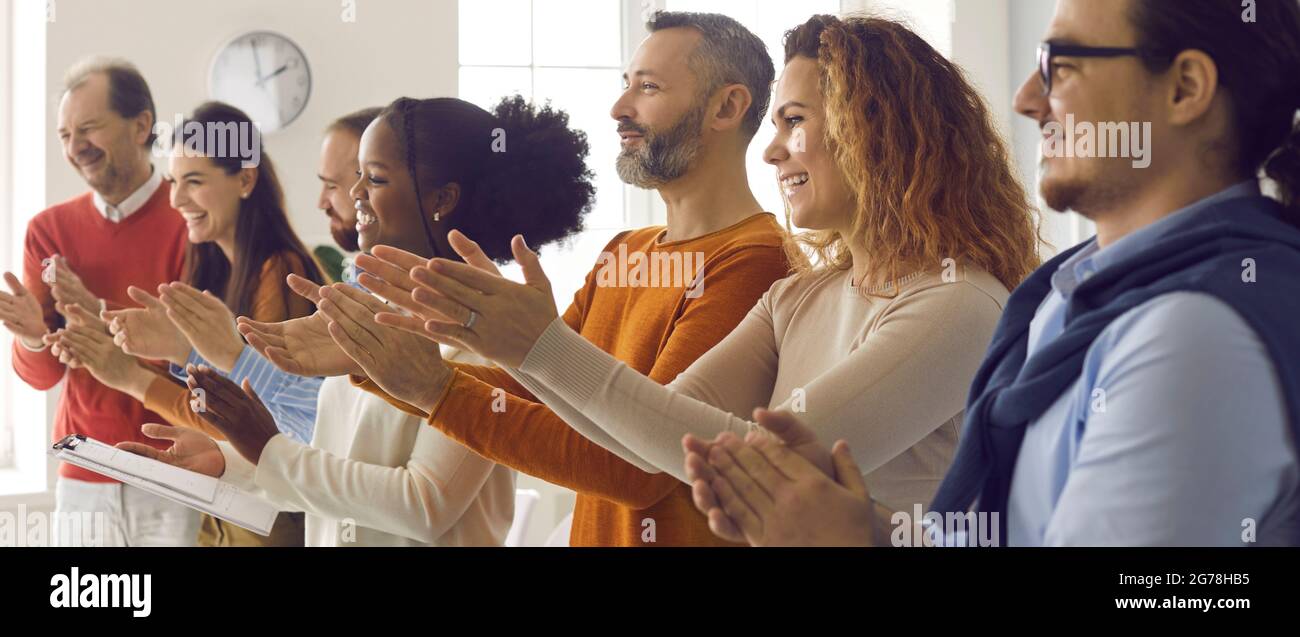 Un pubblico felice e diversificato applaudendo e ringraziando l'oratore o l'allenatore per una buona presentazione Foto Stock