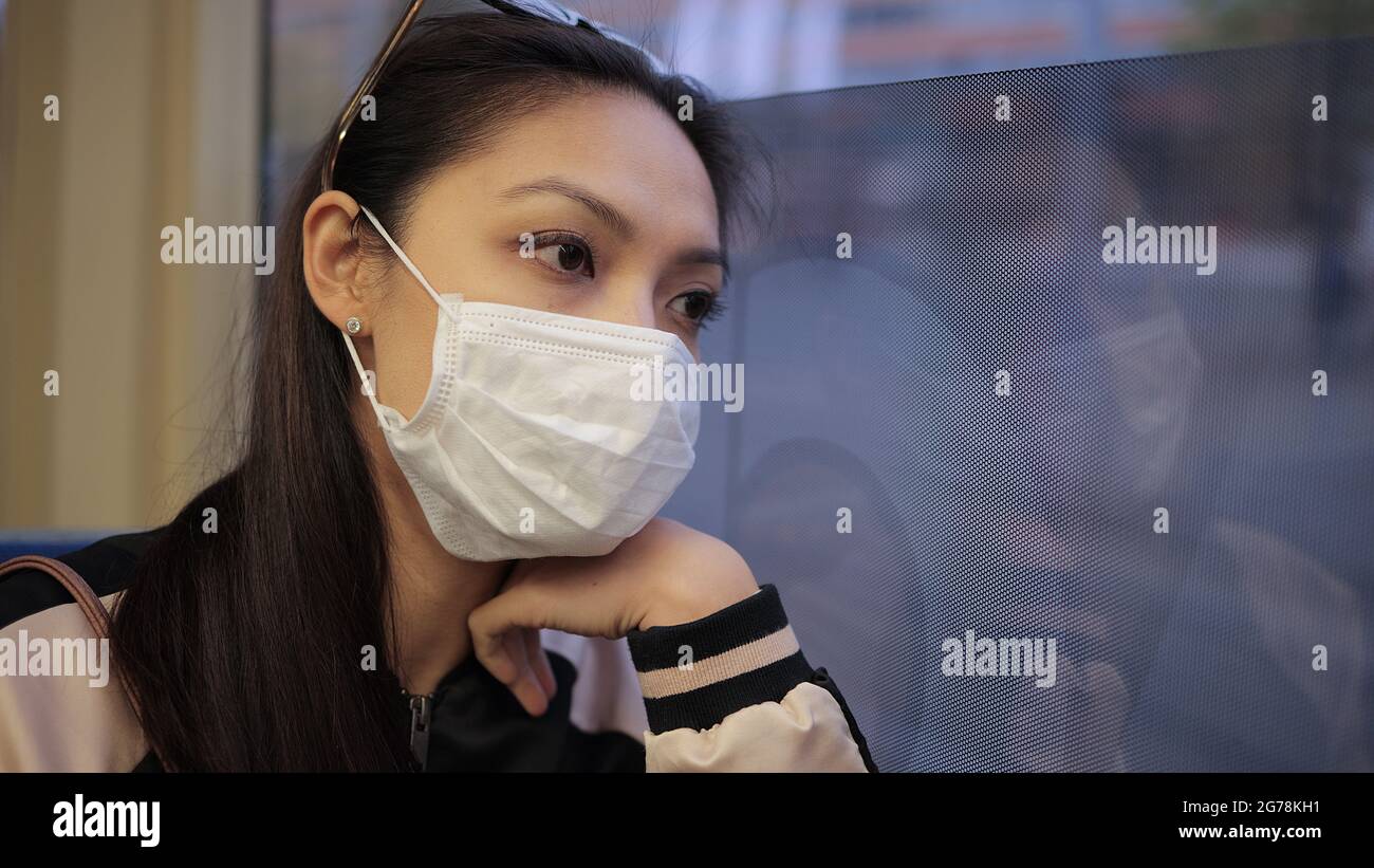 Indossare una maschera mentre si guida in tram - prevenzione del coronavirus Foto Stock