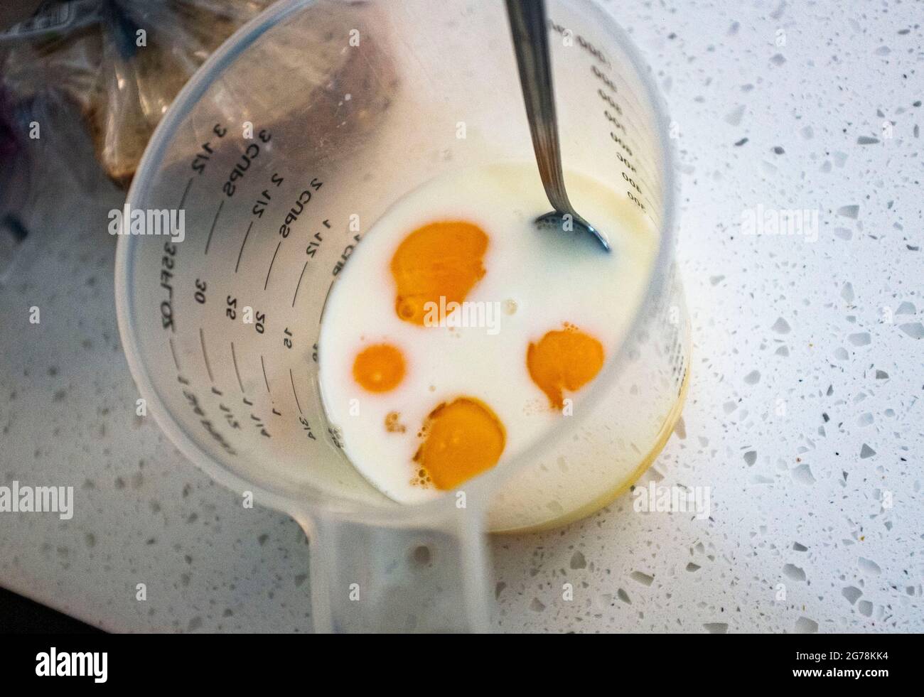 Caraffa dosatore con uova e latte per preparare la colazione a base di uova strapazzate UK Foto Stock