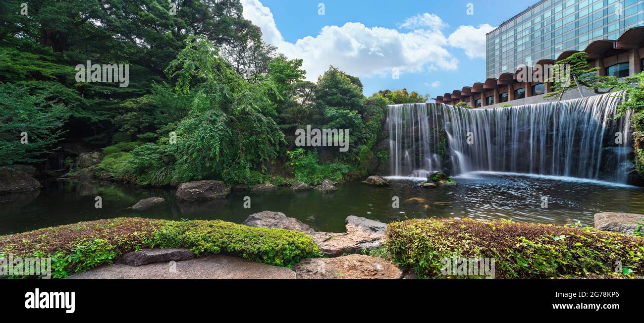 tokyo, giappone - luglio 10 2021: Ampio panorama della grande cascata che si affaccia sullo stagno dell'Hotel New Otani Japanese Garden ai piedi dell'Hotel New Foto Stock