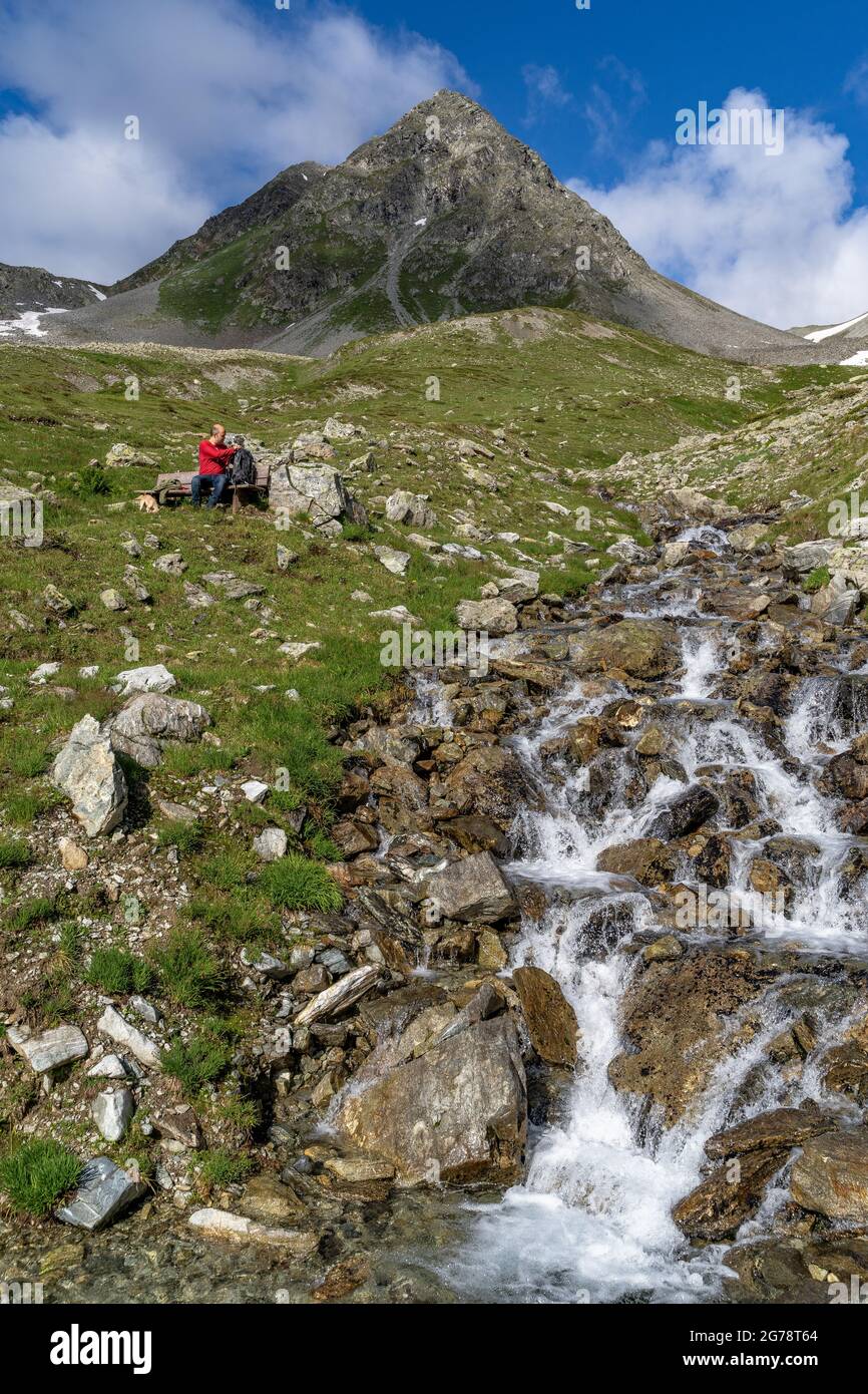 Europa, Austria, Tirolo, Verwall, Paznaun, Galtür, rifugio Friedrichshafener, escursionista si siede su una panchina di fronte allo sfondo del Gaisspitze Foto Stock