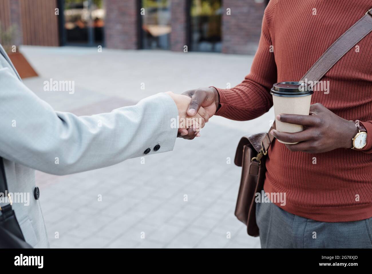 Uomo d'affari con la mano di scuotimento della bevanda di femmina in abito dopo aver fatto accordo Foto Stock