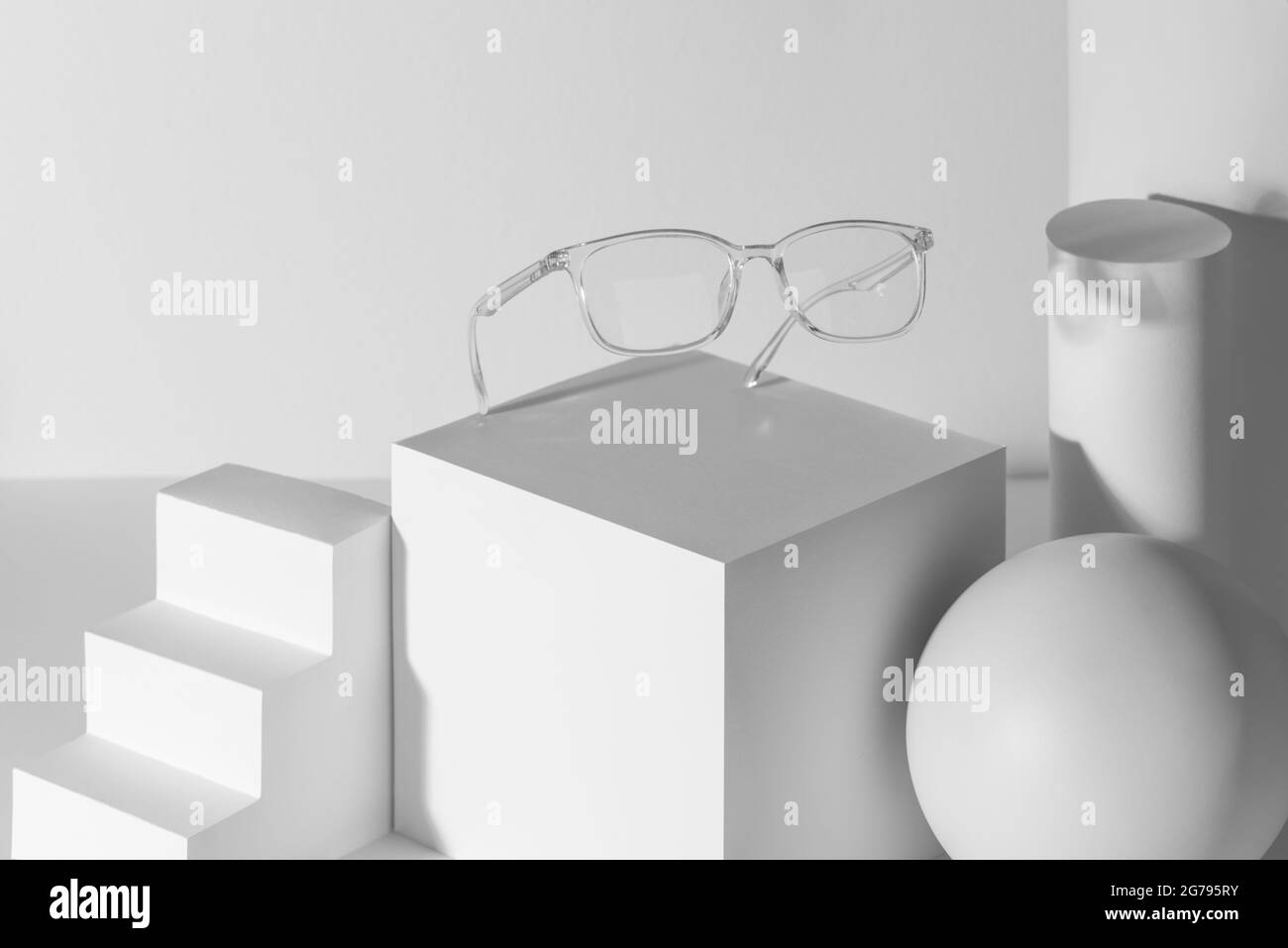 Occhiali trasparenti dimostrati su una serie di forme 3d bianche Foto Stock